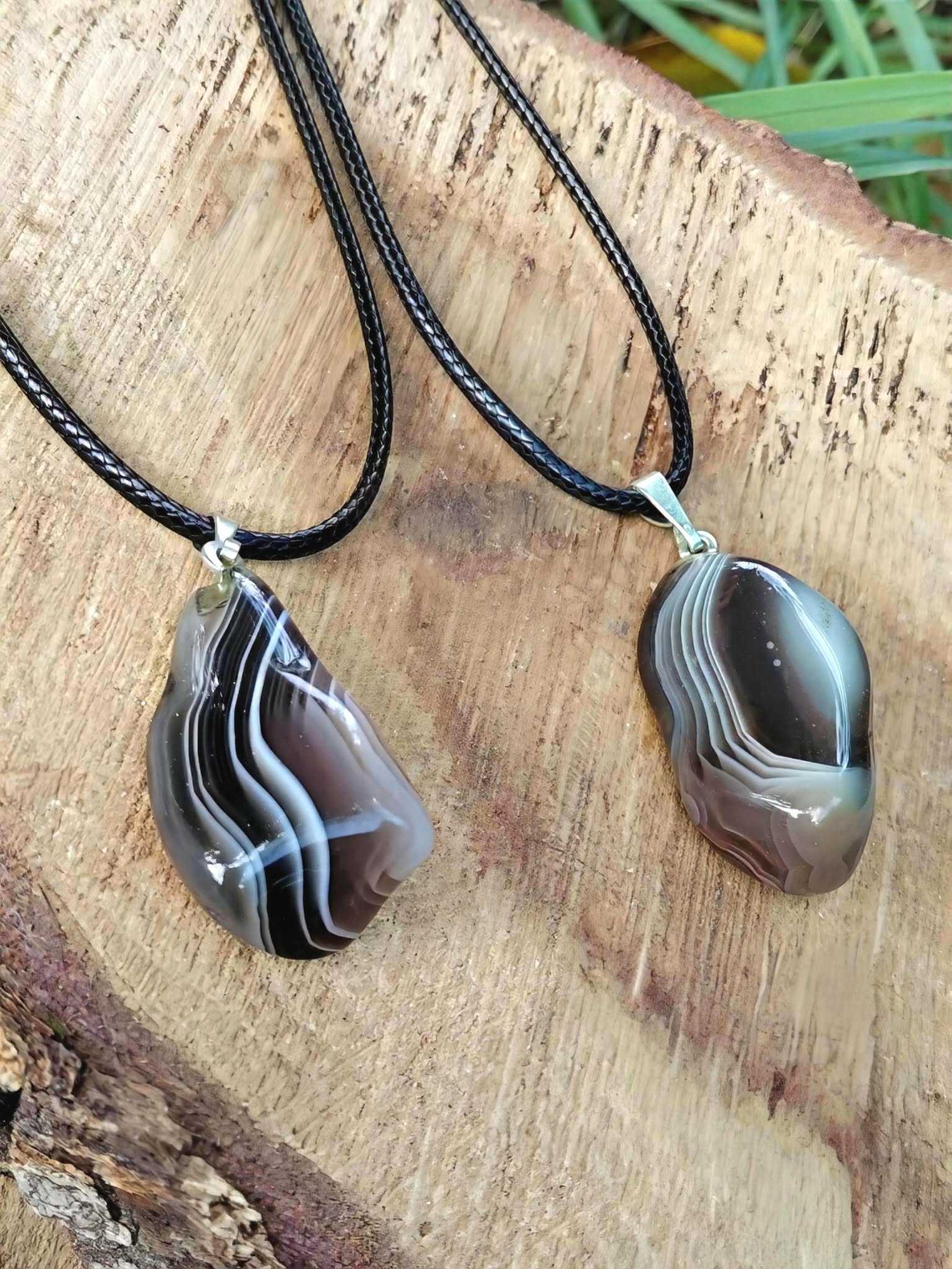 Pendentif agate du Botswana sur planche de bois, harmonie émotionnelle, confort du cœur et sérénité intérieure