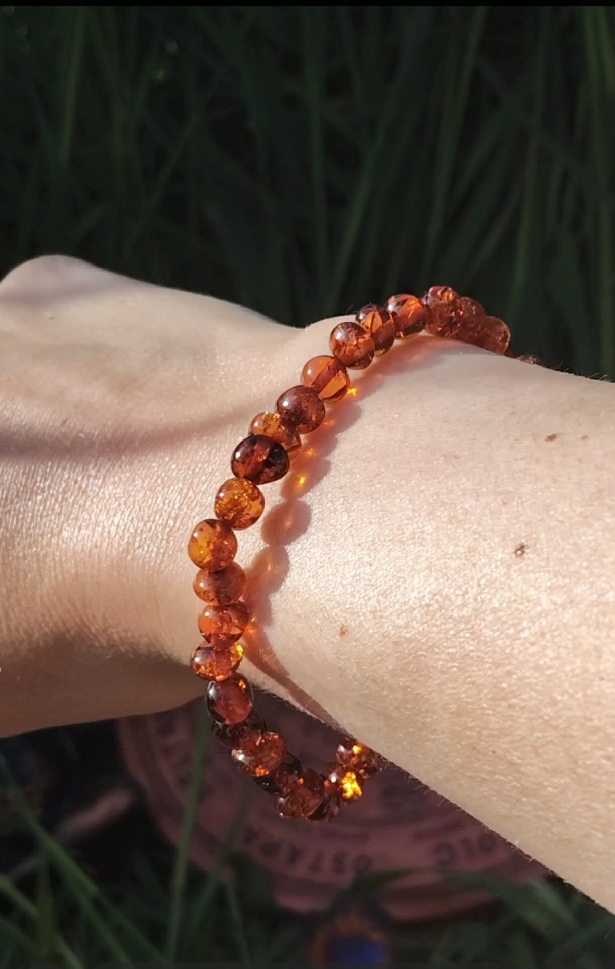 Bracelet ambre naturel couleur miel porté au poignet, perles chaudes et lumineuses pour réconfort intérieur, douceur et énergie solaire