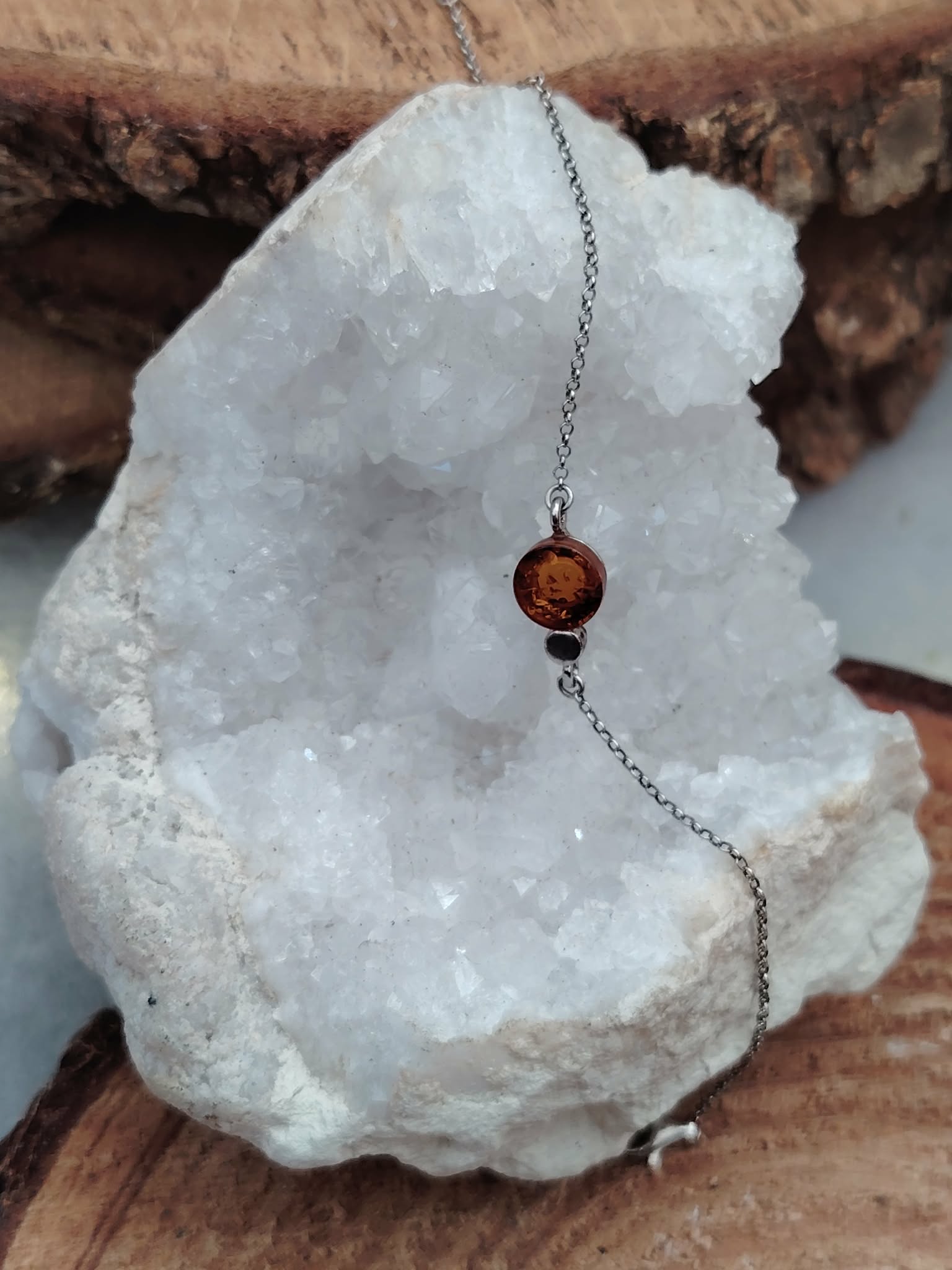 Bracelet ambre baltique cognac sur chaîne en argent 925 rhodié, cabochon miel sur géode de quartz blanc et support bois, énergie solaire et équilibre apaisé.