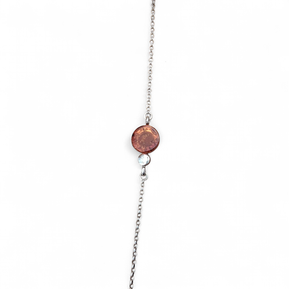 Bracelet ambre baltique cognac sur fond blanc, chaîne fine en argent 925 rhodié et cabochon miel, calme émotionnel, douceur et lumière chaleureuse.