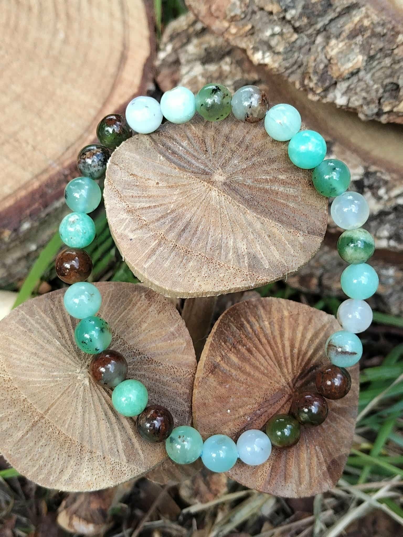 Bracelet chrysoprase posé sur disques de bois avec mousse verte, pierre naturelle pour assurance intérieure et estime de soi apaisée