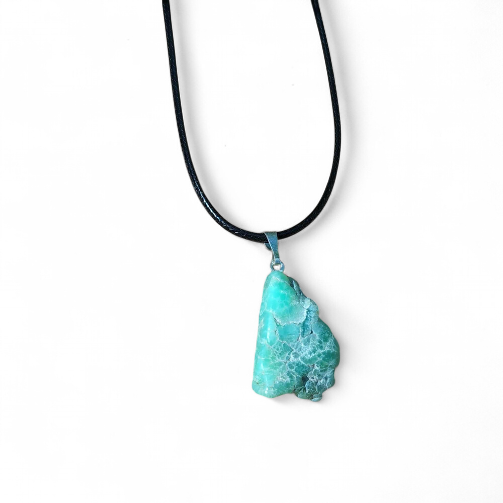 Pendentif chrysoprase naturelle brute sur cordon noir, présenté sur fond blanc, pierre fine verte reliée à la tendresse émotionnelle, à la sérénité et à l’équilibre intérieur.