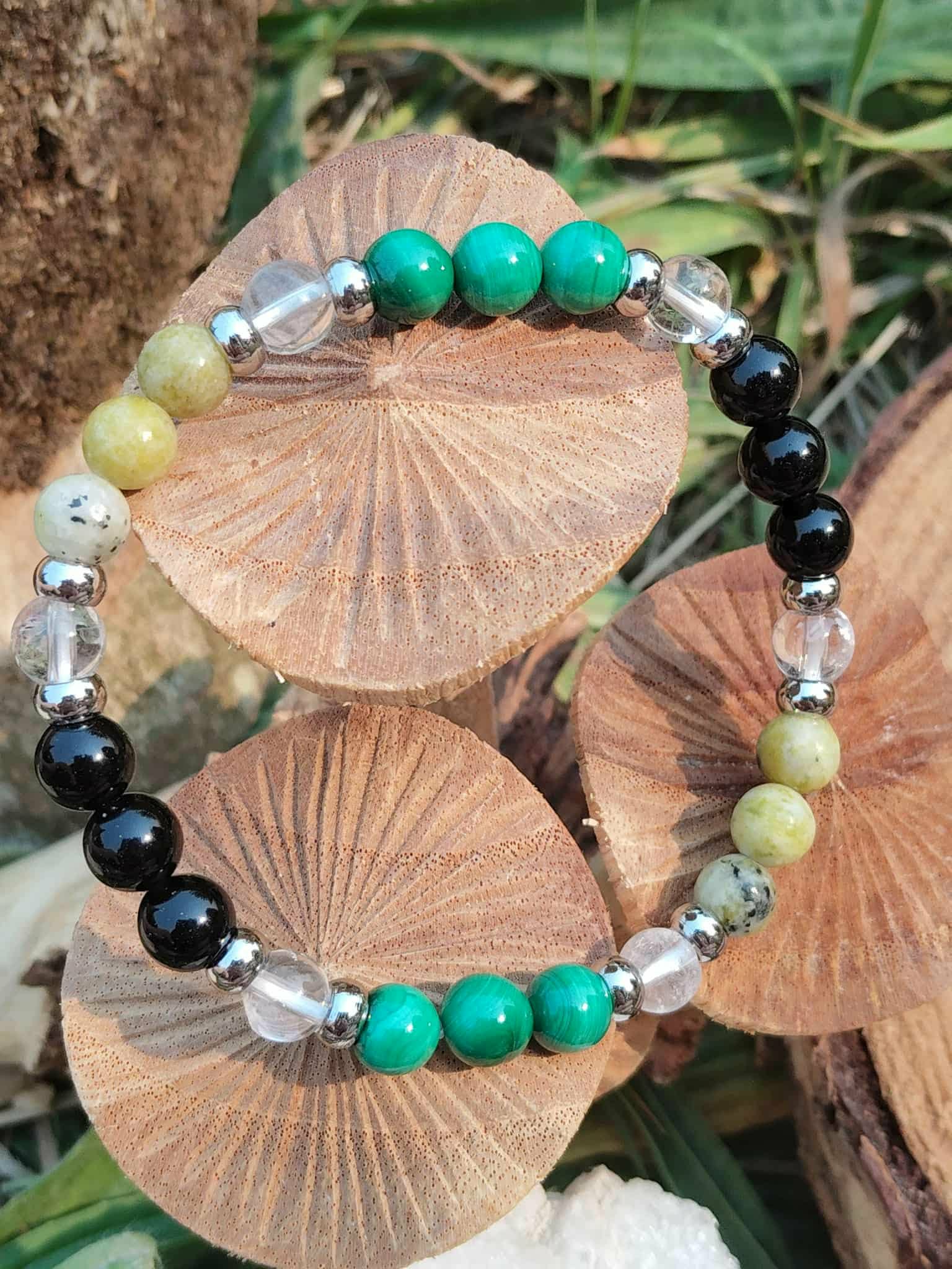 Bracelet Fibromyalgie serpentine et malachite sur rondin en lumière naturelle, soutien émotionnel et équilibre plus stable