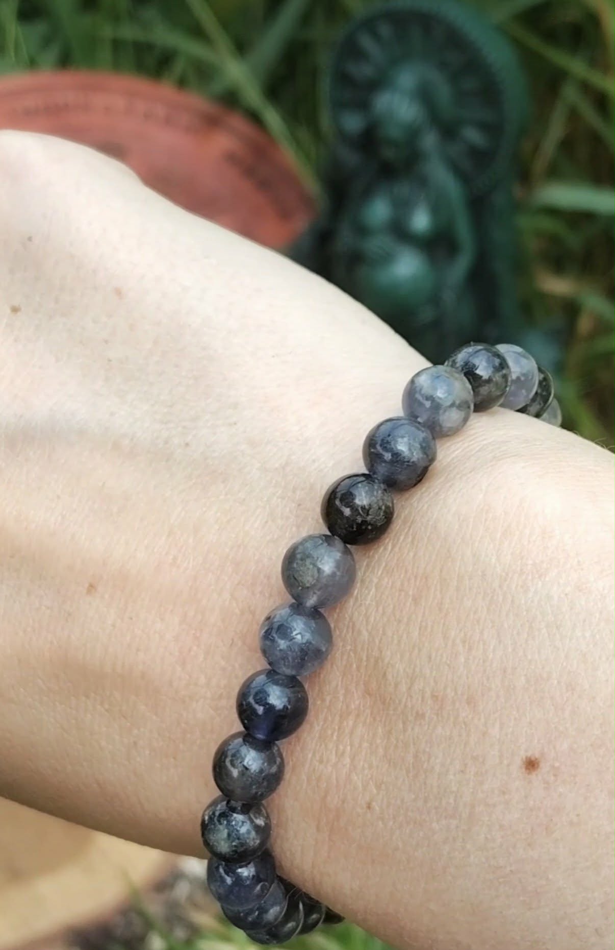 Bracelet iolite en pierre naturelle porté au poignet, perles bleu fumé aux reflets bleutés pour présence calme, ancrage léger et confiance intérieure