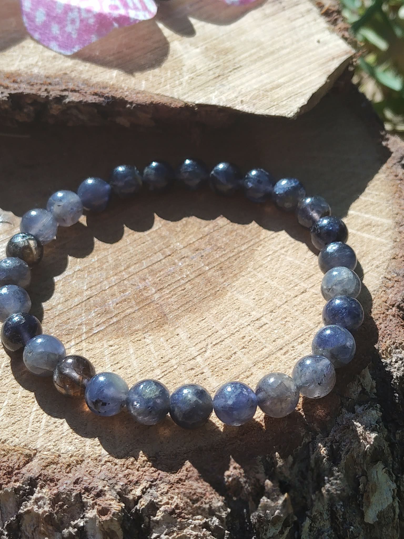 Bracelet iolite sur fond blanc, perles bleu violet et gris bleuté aux reflets indigo pour recul lucide, sérénité émotionnelle et esprit plus net
