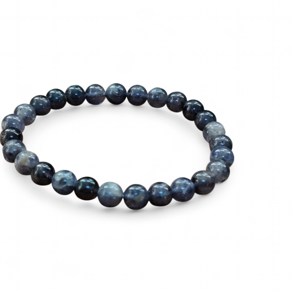 Bracelet iolite sur fond blanc, perles bleu violet, gris bleuté et reflets indigo, prise de recul, équilibre émotionnel et calme intérieur