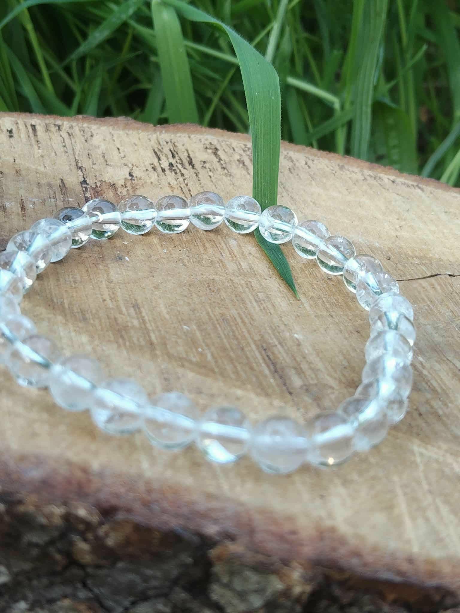 Bracelet cristal de roche 6 mm sur décor bois naturel avec tiges vertes, transparence des perles mise en valeur pour intuition et esprit clair