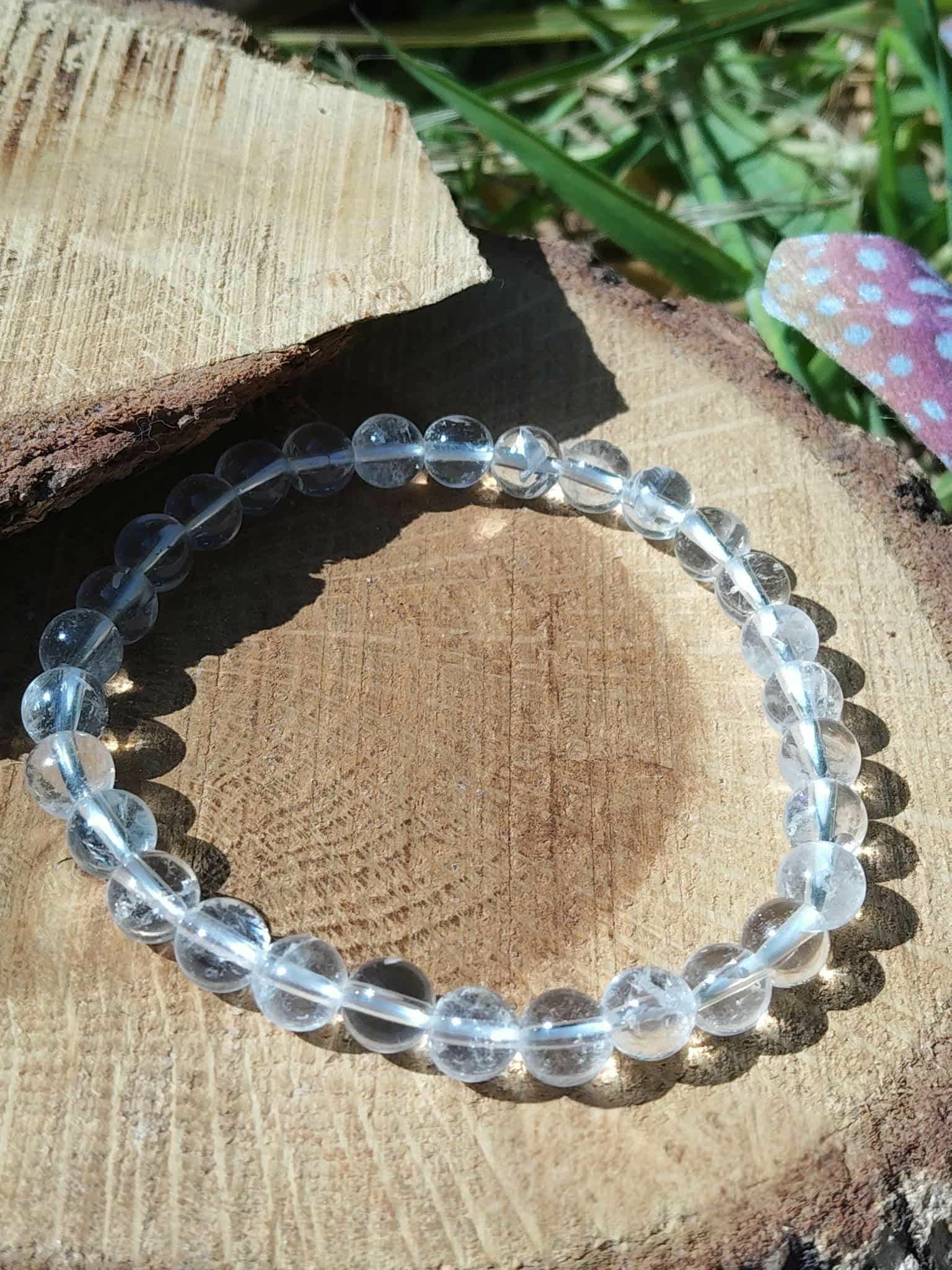 Bracelet cristal de roche 6 mm en cercle sur rondin de bois naturel, perles transparentes polies pour clarté mentale et énergie lumineuse