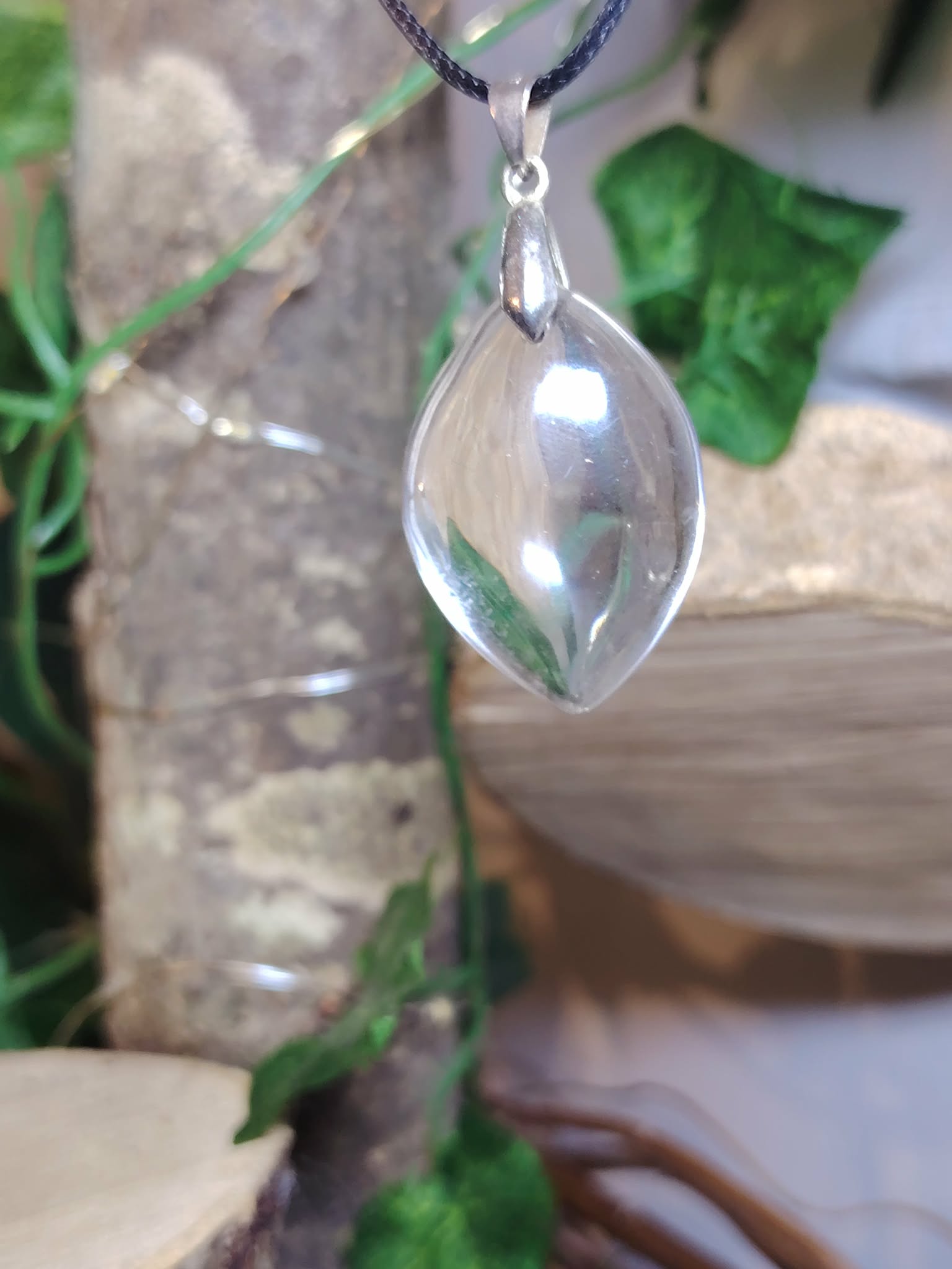 pendentif pierre naturelle cristal de roche goutte sur cordon noir, fond déco végétal et pierre sélénite — concentration