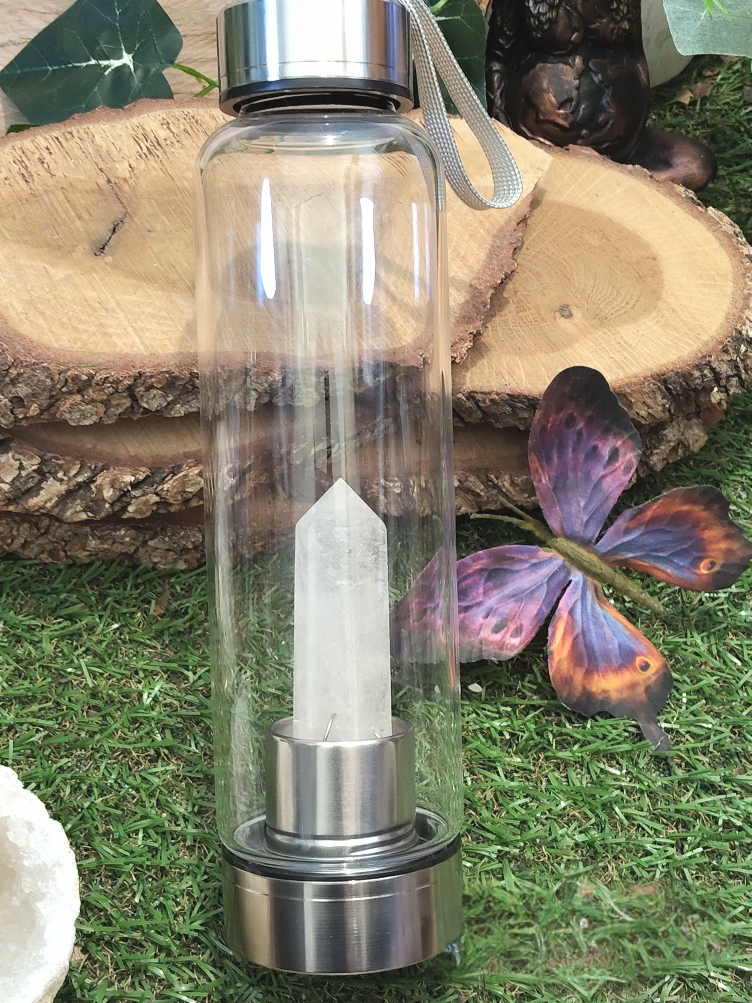 bouteille deau en verre énergisant cristal de roche, gourde transparente avec bouchon inox et dragonne, pointe de cristal de roche intégrée, décor nature bois et papillon