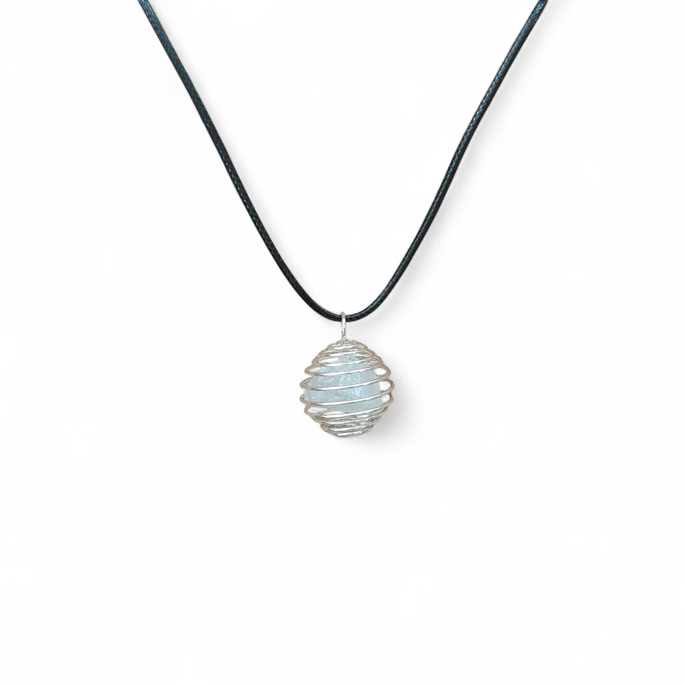 pendentif-cage-spirale-avec-amas-de-quartz-cristal-de-roche-sur-cordon-noir-pose-sur-tranche-de-bois-associe-a-la-clarte-l-harmonisation-et-l-amplification-des-intentions-symbolique