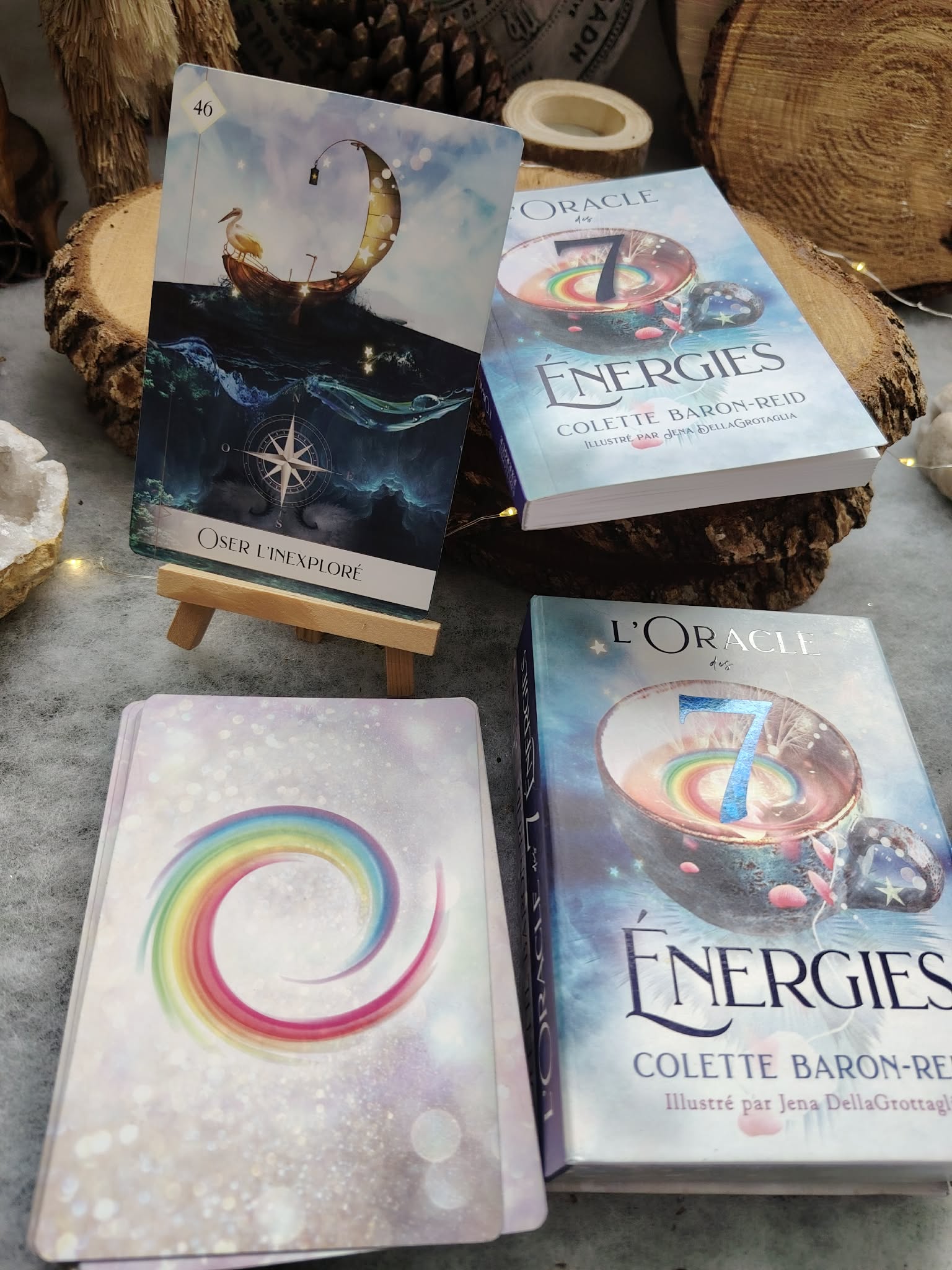 L’Oracle des 7 Énergies – coffret divinatoire avec boîtes et cartes visibles, posé sur table en bois dans une ambiance ésotérique, éléments naturels et pierres en décoration.