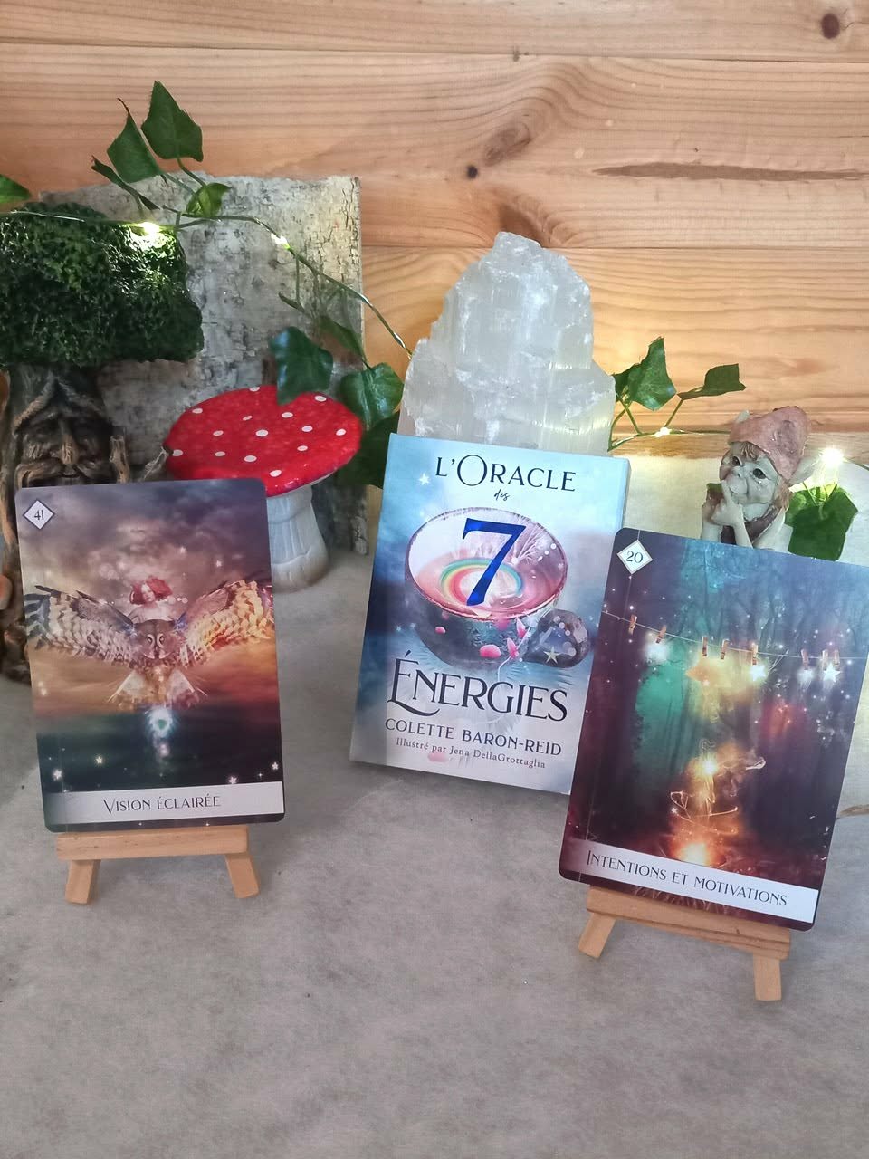 Oracle des 7 Énergies : coffret   cartes exposées sur chevalets, ambiance ésotérique nature avec plantes et accessoires.