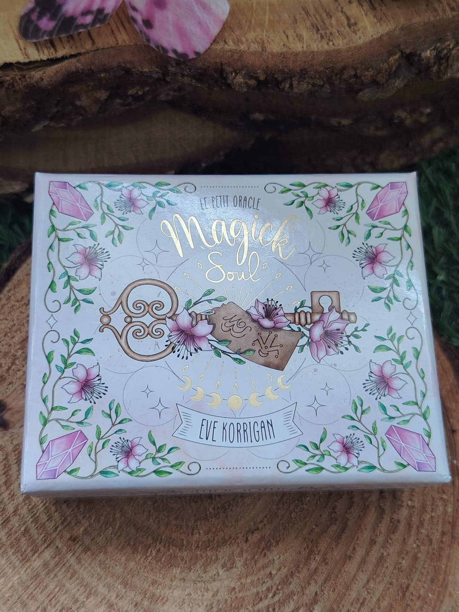 Coffret oracle Magic Soul en photo lifestyle, boîte illustrée sur rondin de bois, atmosphère douce et ésotérique.