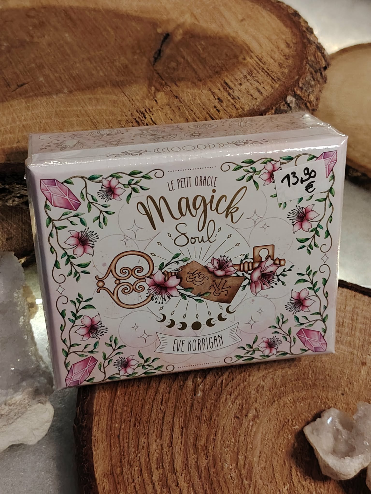 Oracle Magic Soul Eve Korrigan (coffret fermé) présenté sur support en bois rustique, décor pierres claires en arrière-plan.