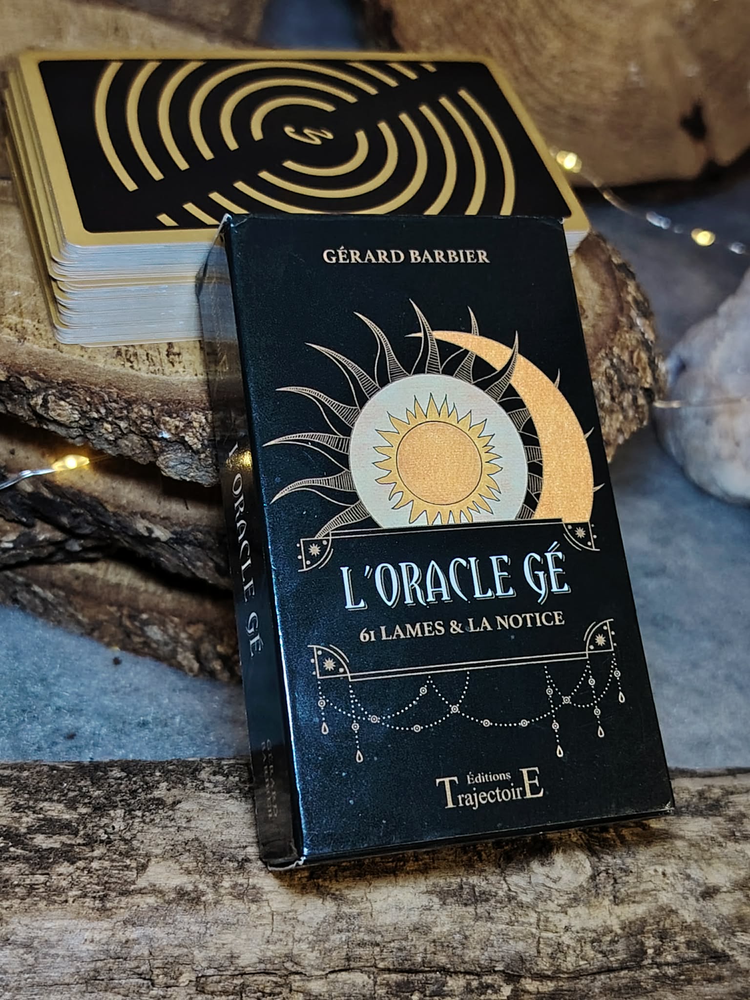 Jeu divinatoire Oracle Gé en scène complète, boîte au premier plan avec cartes derrière et petite géode