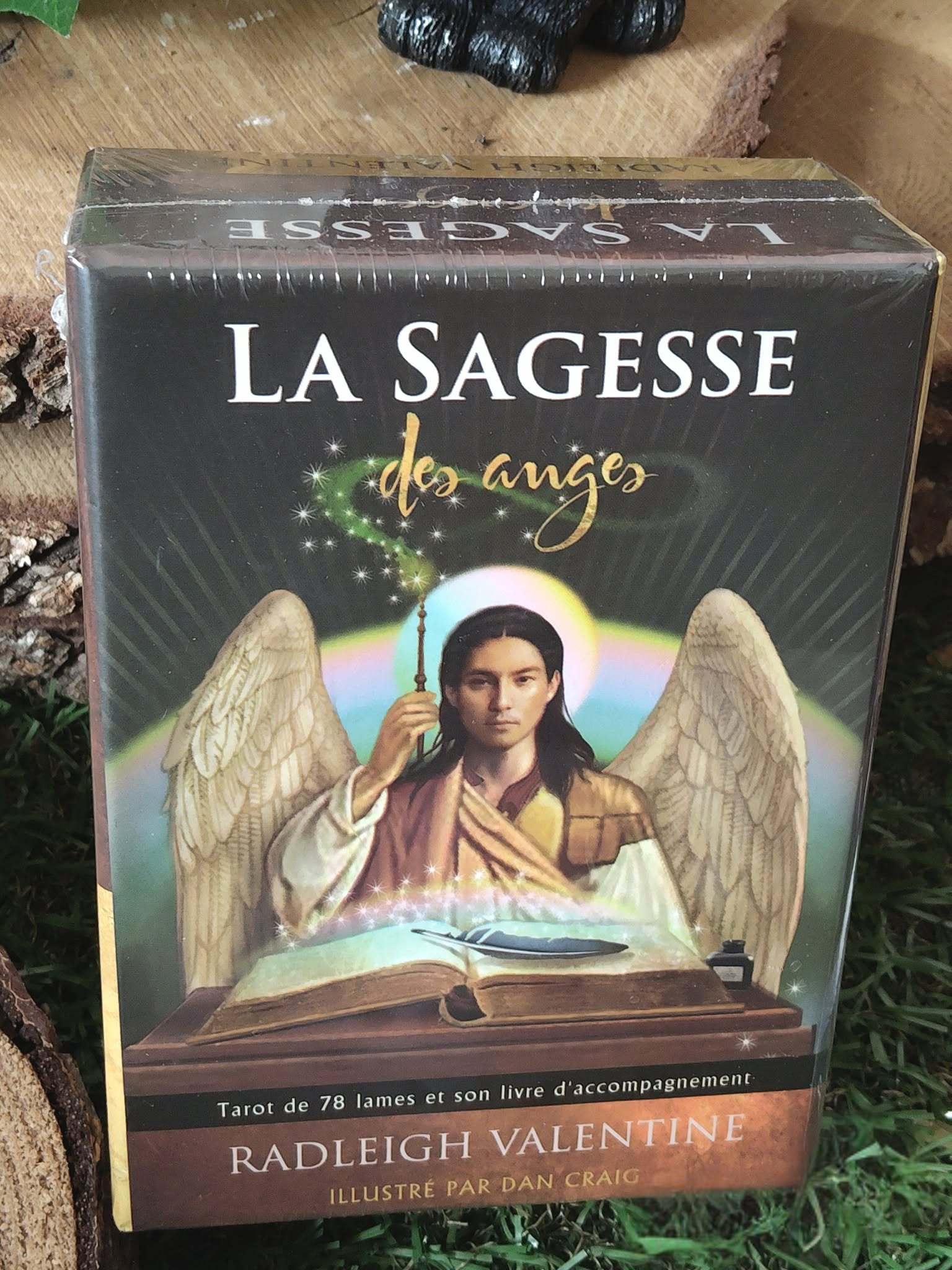 La Sagesse des Anges (Radleigh Valentine) : boîte du tarot en gros plan, illustration d’un ange aux ailes déployées, décor bois et feuillage.