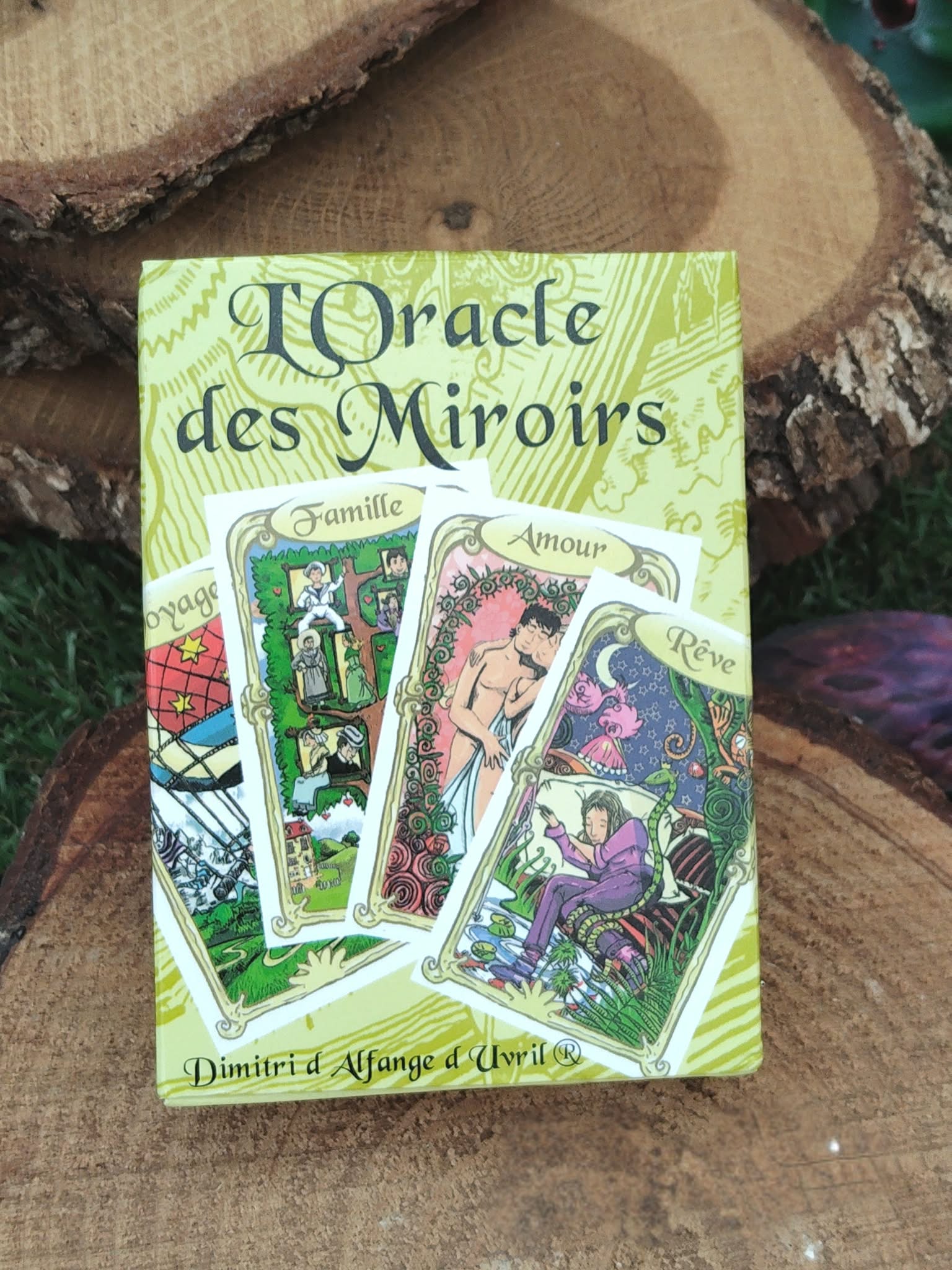 Oracle des miroirs Éditions Trajectoire, coffret de 53 cartes divinatoires, posé sur rondin de bois avec fond sombre ésotérique.