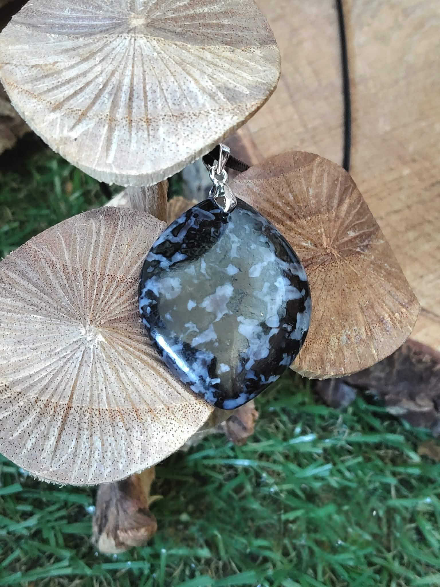 Pendentif indigo gabbro en macro, pierre naturelle sombre aux motifs profonds en décor extérieur, bijou évoquant l’introspection, le discernement et la profondeur intérieure.