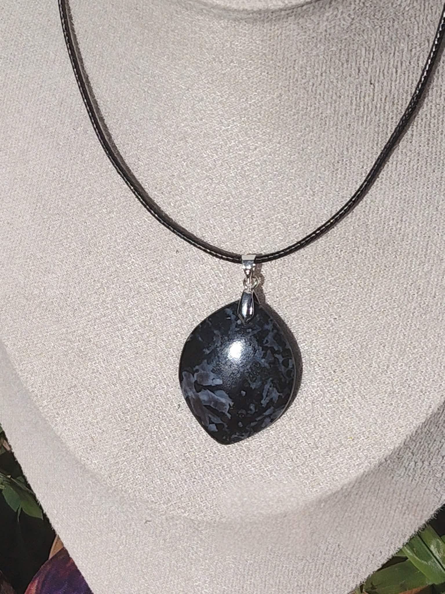 Collier pendentif indigo gabbro en forme de goutte porté sur cordon noir, bijou sobre en pierre naturelle associé à l’assurance, à l’ancrage et à la tenue intérieure.