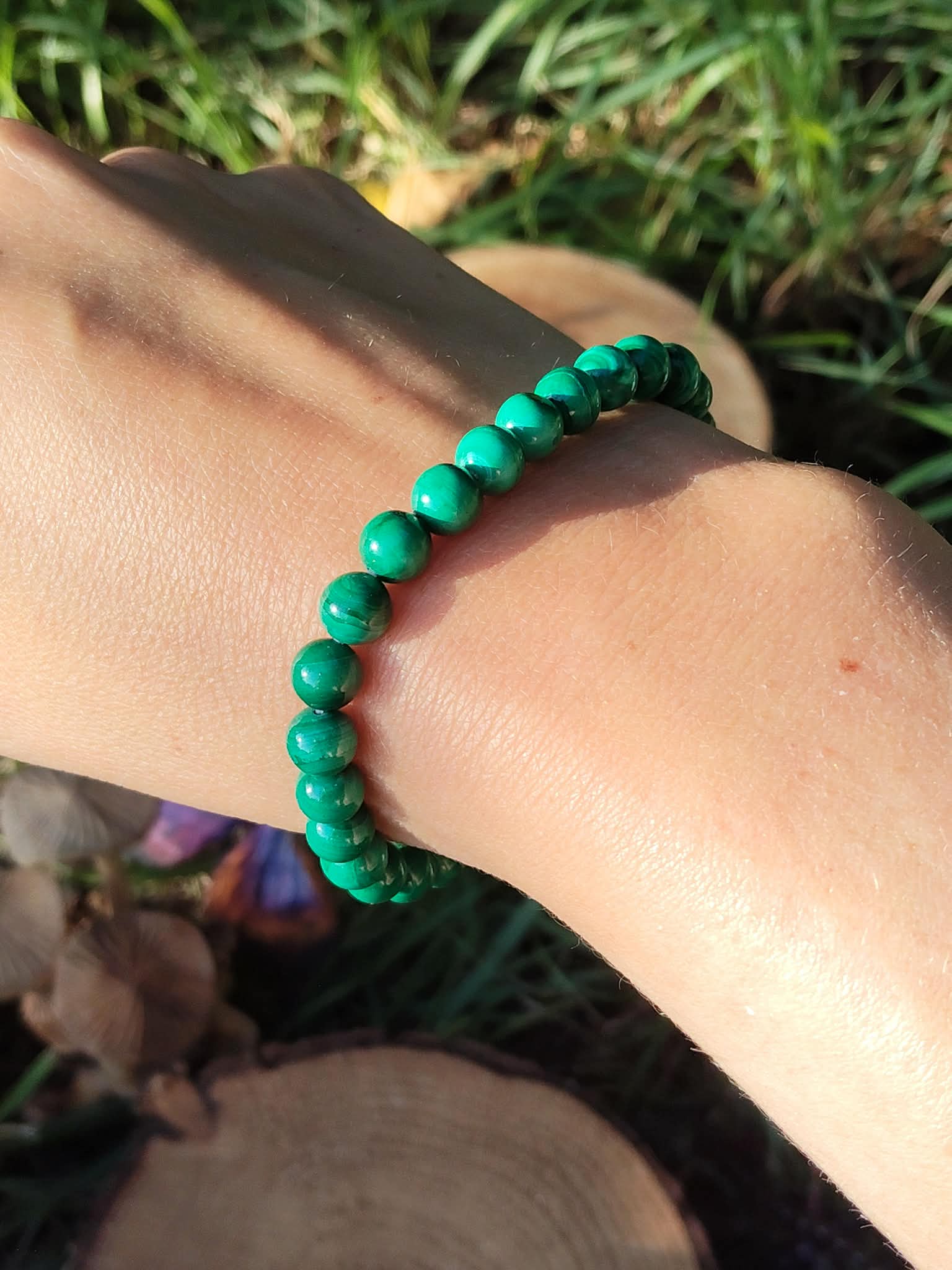 Bracelet malachite 6 mm porté au poignet, perles vertes marbrées dans un décor végétal, bijou en pierre naturelle pour ancrage