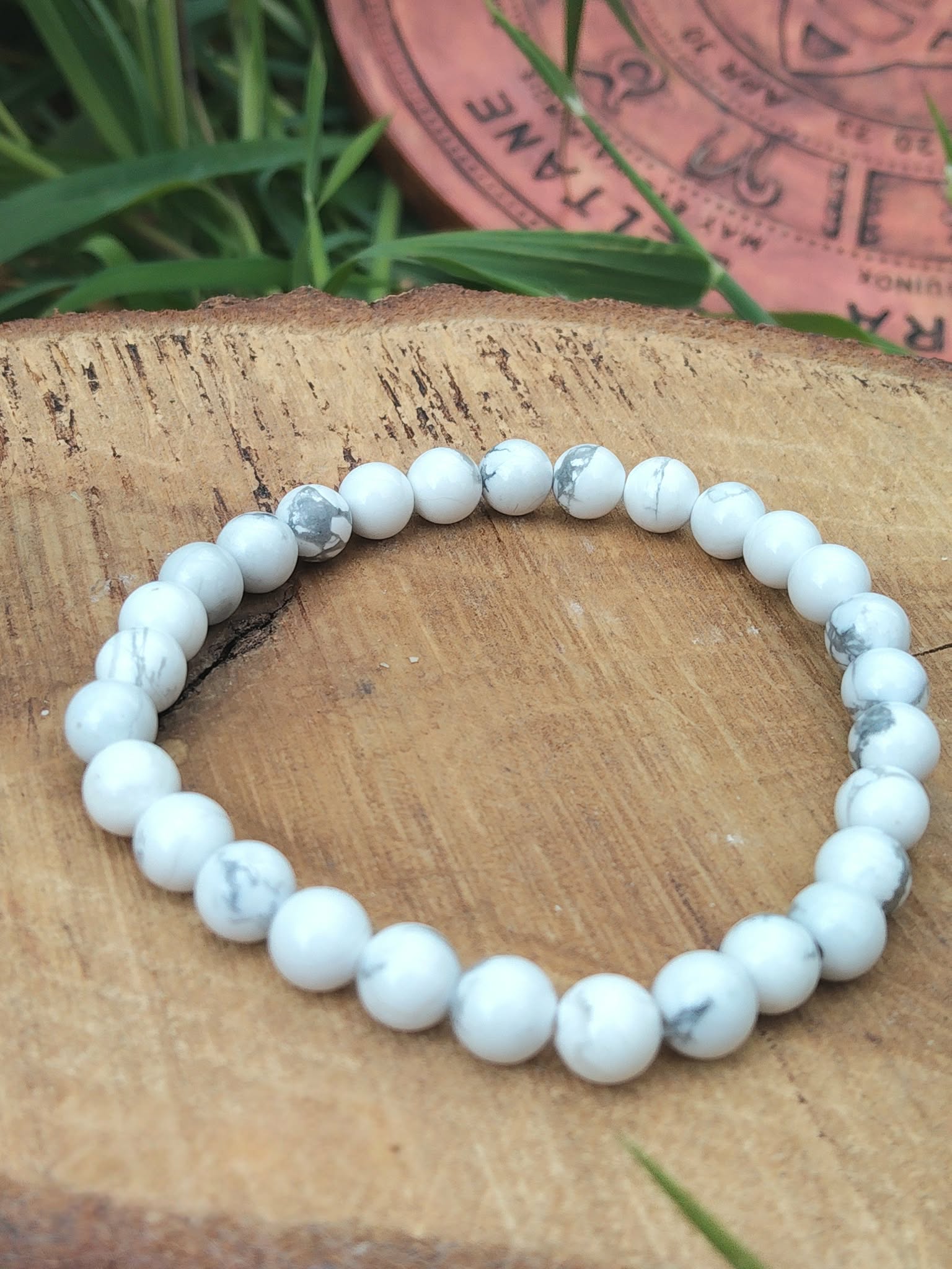 Bracelet howlite blanche 6 mm sur tranche de bois avec fond végétal et décor gravé, patience, solidité du ressenti et paix intérieure