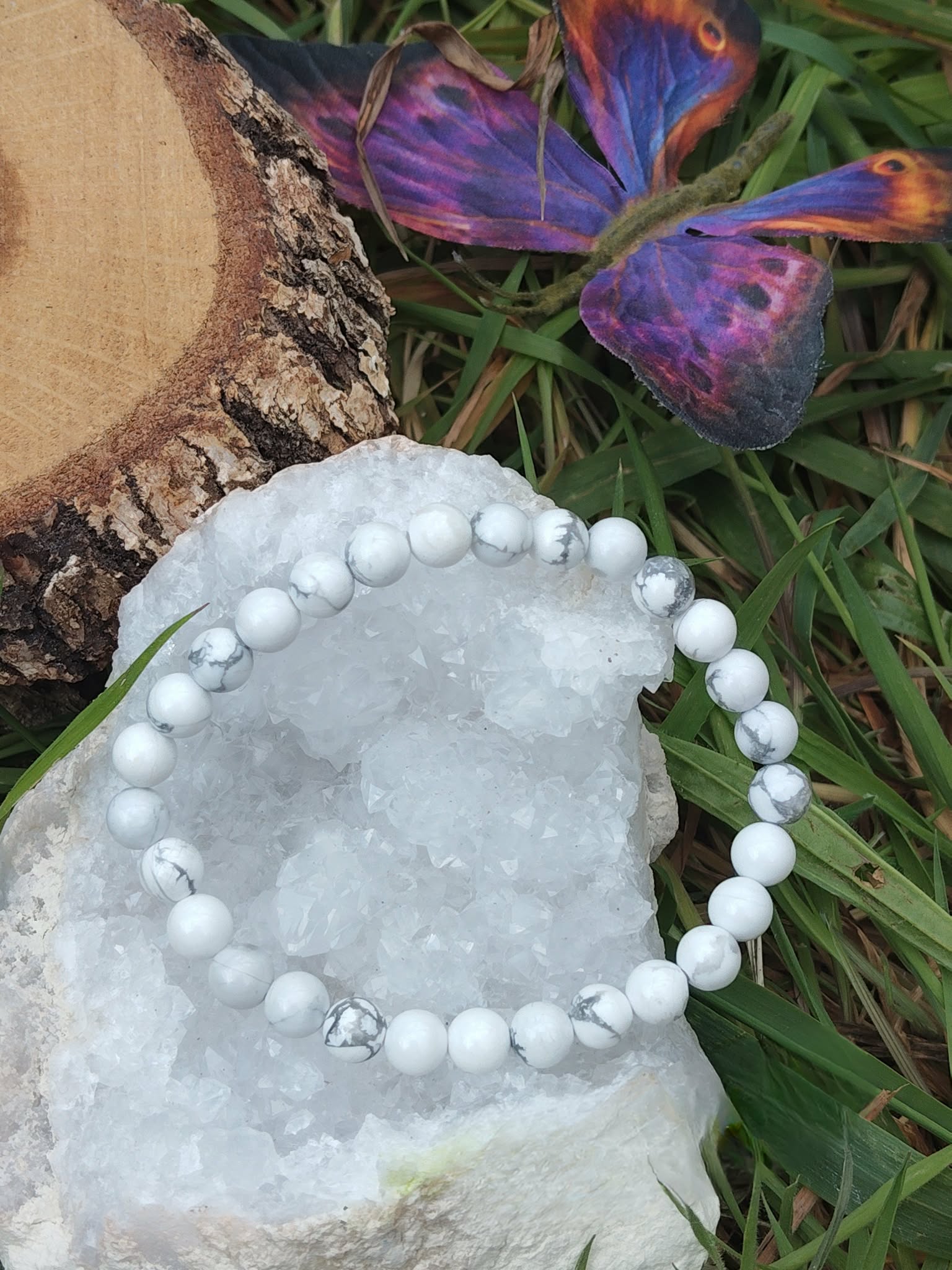 Bracelet howlite blanche 6 mm sur géode de quartz avec herbe et papillon coloré, perles blanches veinées de gris, clarté douce, apaisement et harmonie intérieure