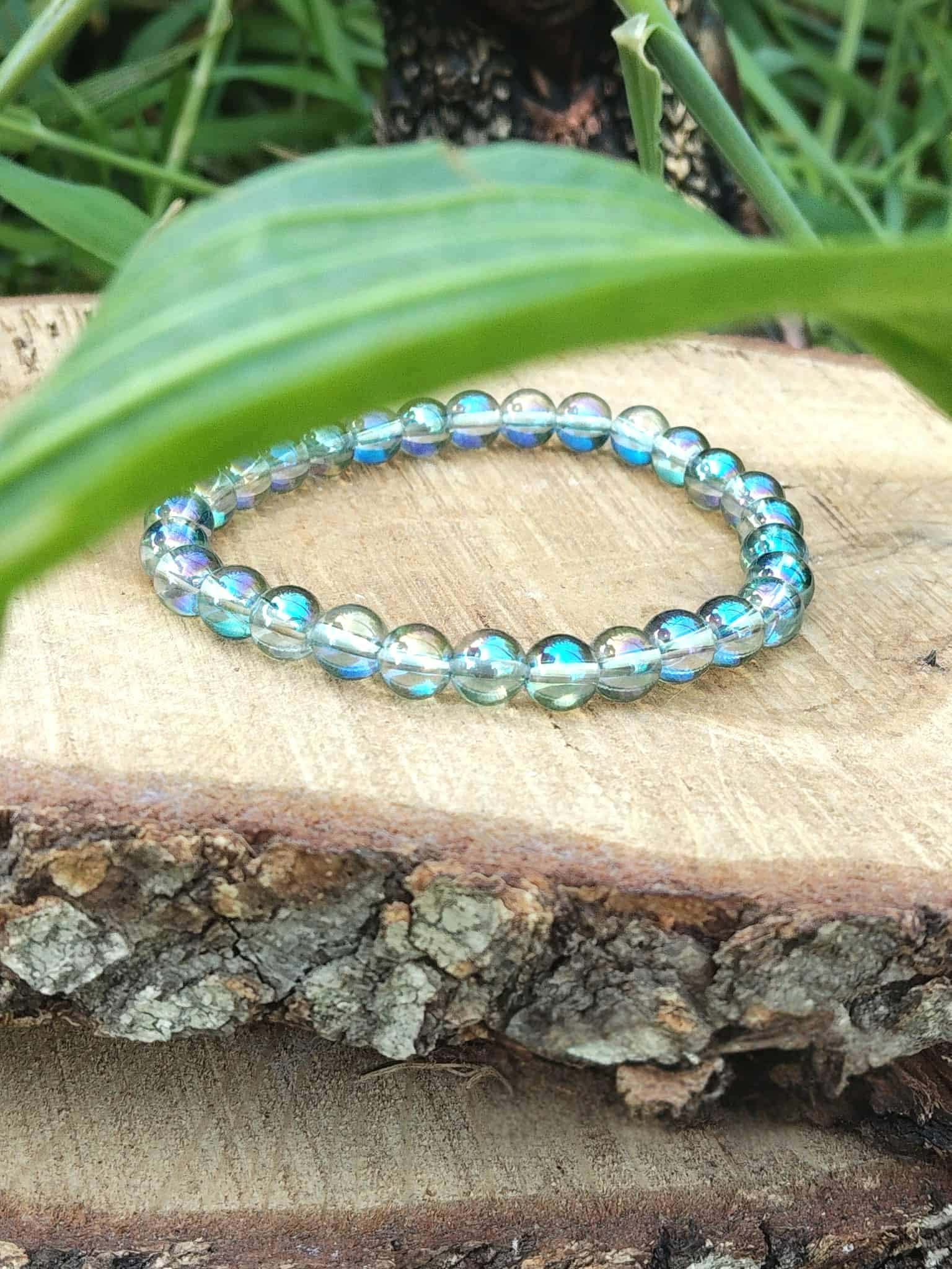 Bracelet Aqua Aura sur bois texturé, quartz bleu irisé aux reflets changeants, paix intérieure, ouverture intuitive et douceur vibratoire