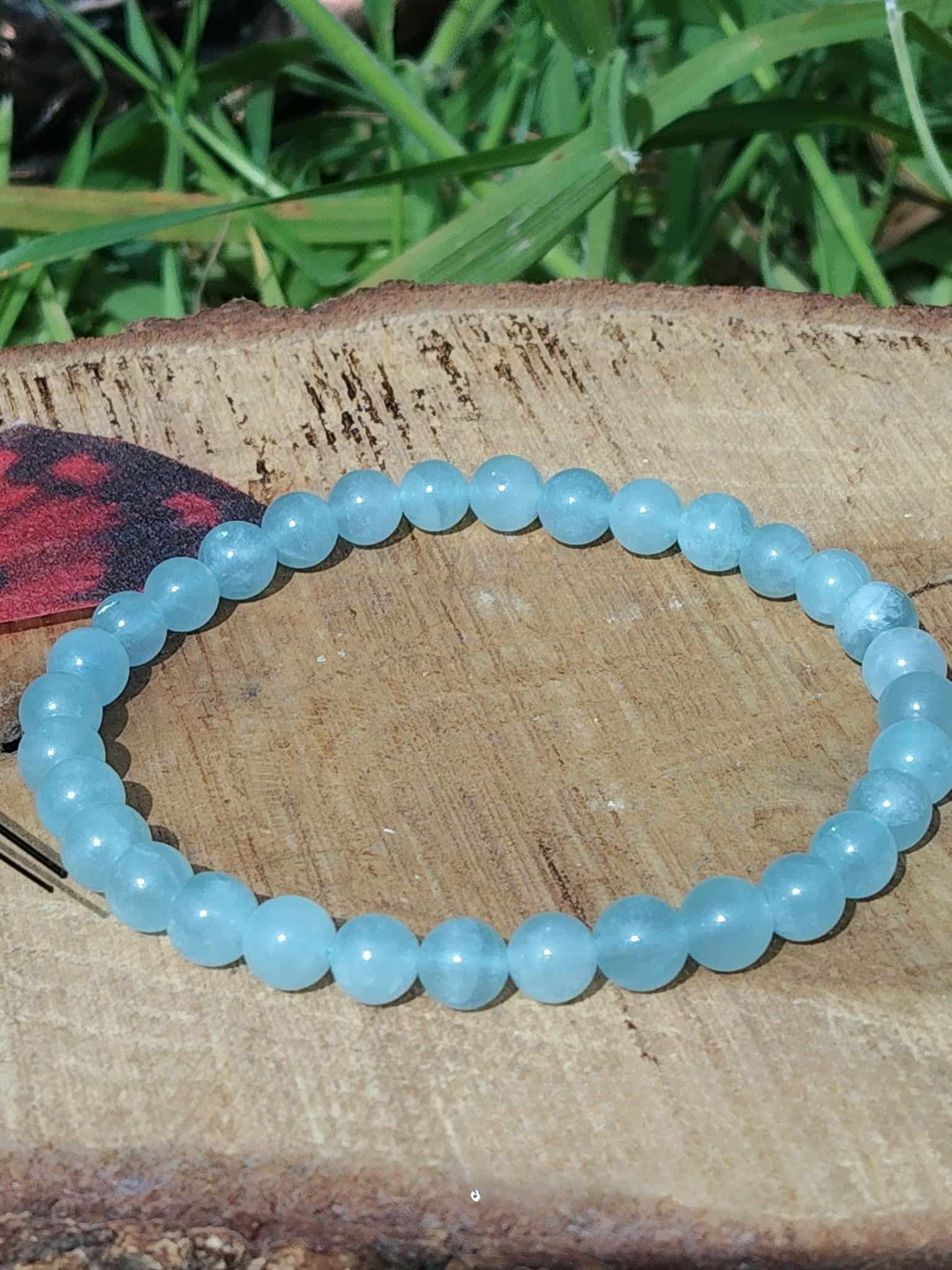 Bracelet Aigue-Marine 6 mm sur rondin de bois avec décor végétal, perles bleu mer translucides, paix intérieure et retour au calme.