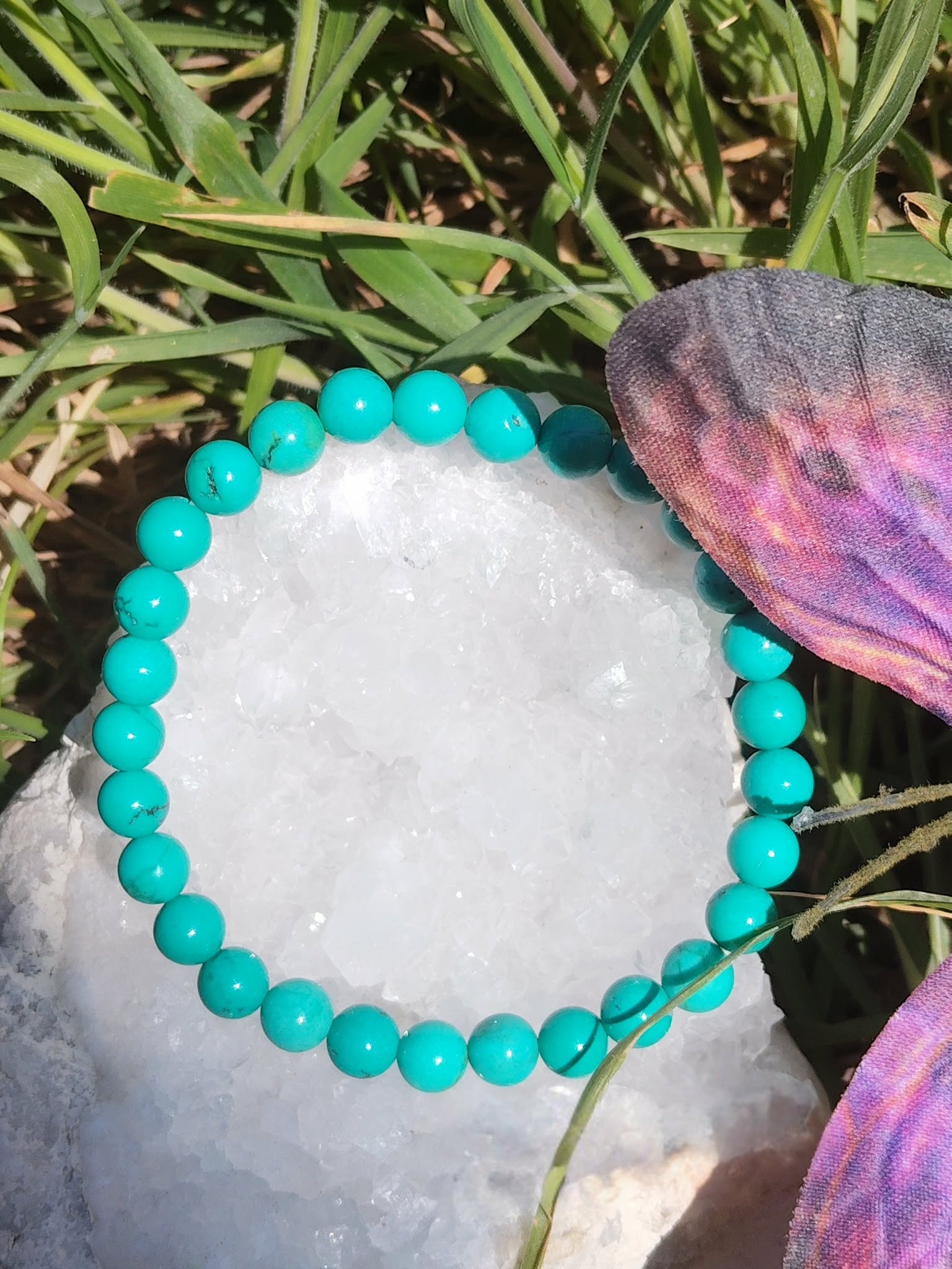 bracelet turquoise perles bleues sur coquille blanche herbes et papillon violette intuition méditation et guidance intérieure