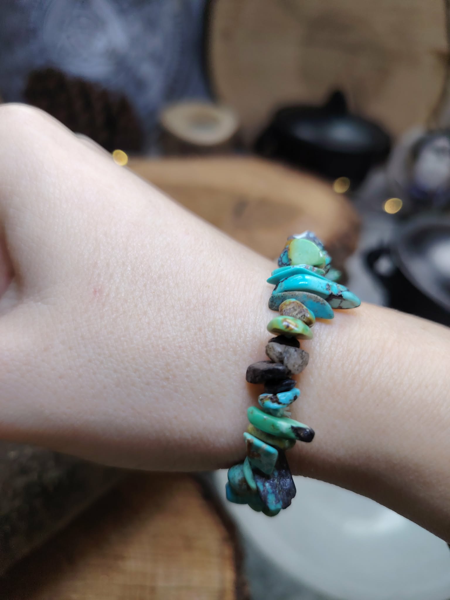 Bracelet turquoise baroque porté au poignet devant bol de sélénite et décor bois, protection douce en voyage et énergie plus sereine