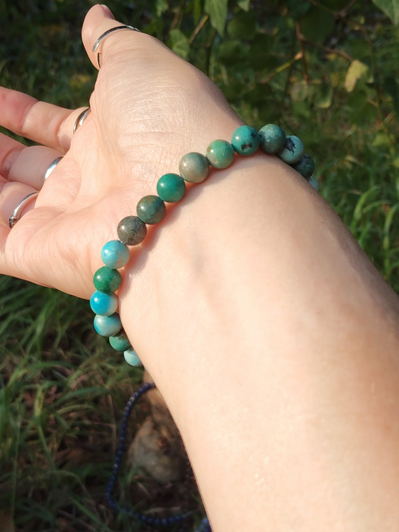 Bracelet turquoise du Tibet porté au poignet en lumière naturelle, perles bleu-vert mates, ancrage apaisé et parole fluide