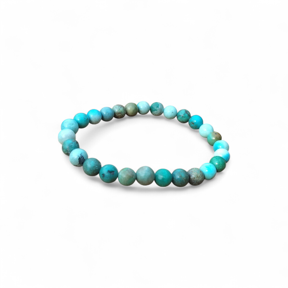 Bracelet turquoise du Tibet sur fond blanc, perles rondes bleu lagon et vert minéral, bijou en pierre naturelle pour confiance et protection.
