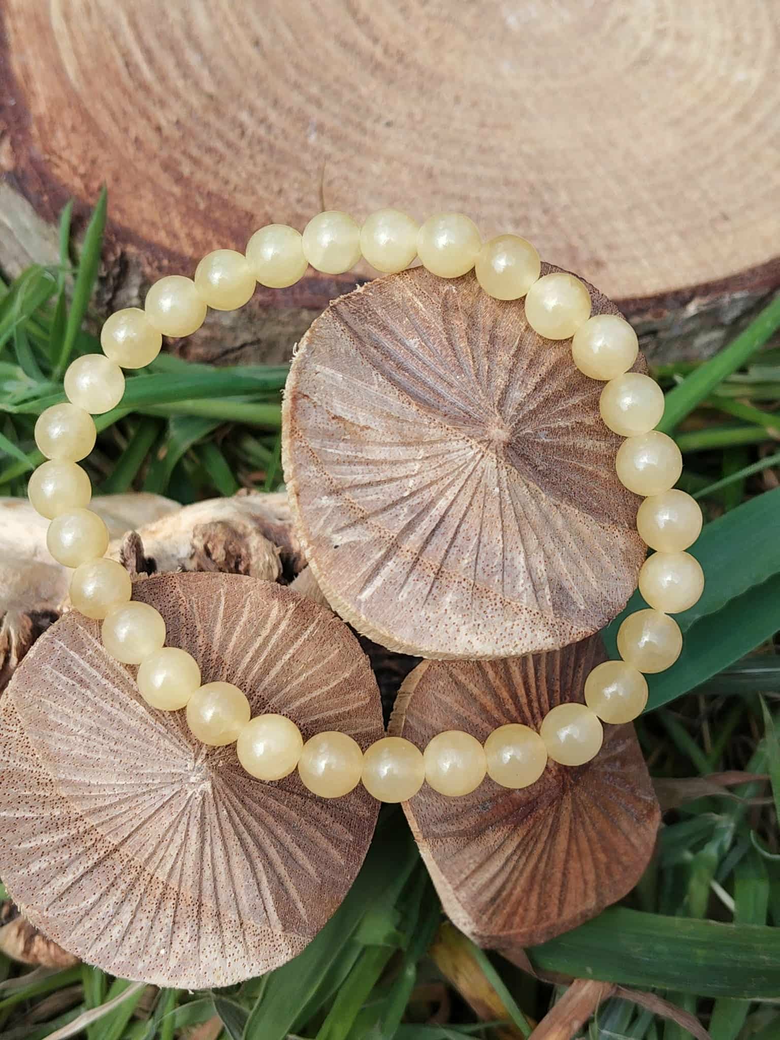 Bracelet calcite jaune porté au poignet, perles rondes aux reflets dorés, dynamisme doux, assurance et rayonnement personnel