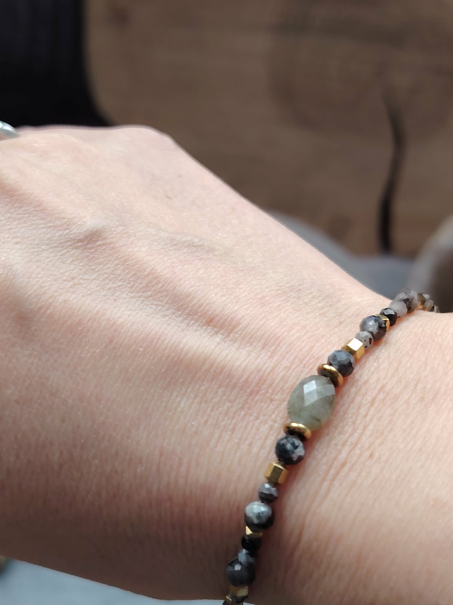 Bracelet labradorite facettée porté au poignet, bijou fin aux reflets gris bleu et détails dorés, confiance intérieure et discernement