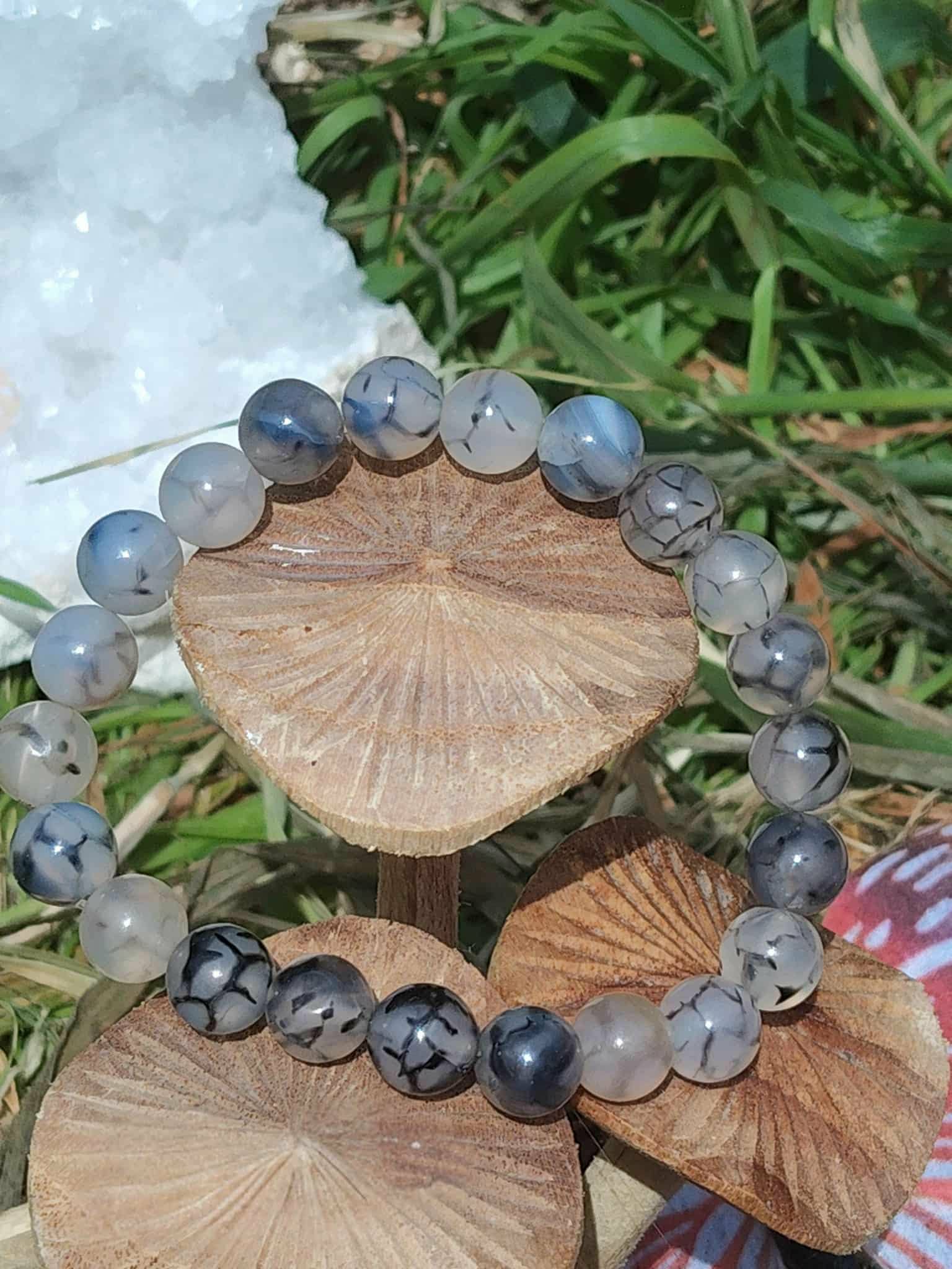 Gros plan du bracelet Agate Veine de Dragon 8 mm teintée sur tranche de bois, décor nature, recul émotionnel et maîtrise de soi