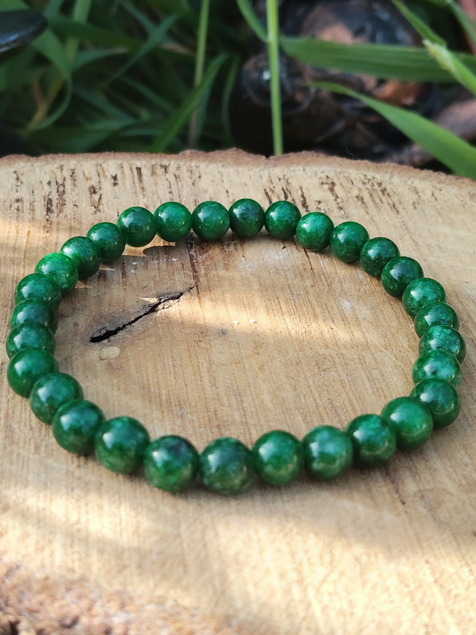Bracelet jade africain 6 mm sur tranche de bois clair avec feuillage vert, perles vert émeraude et vert forêt marbré pour ancrage doux et calme intérieur
