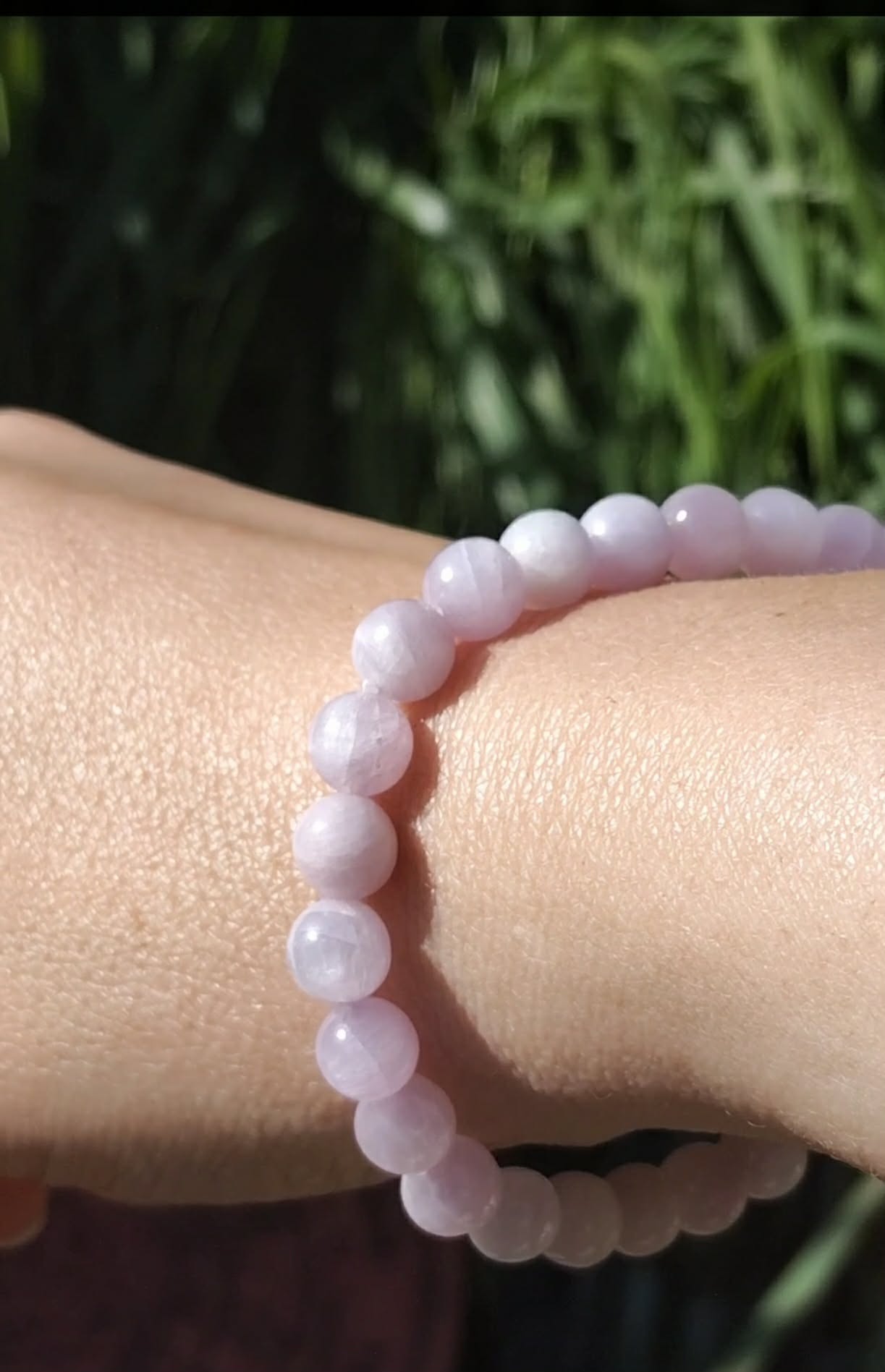 Bracelet kunzite 6 mm porté au poignet, perles rose pâle et lilas translucides pour douceur affective, calme du cœur et réconfort intérieur