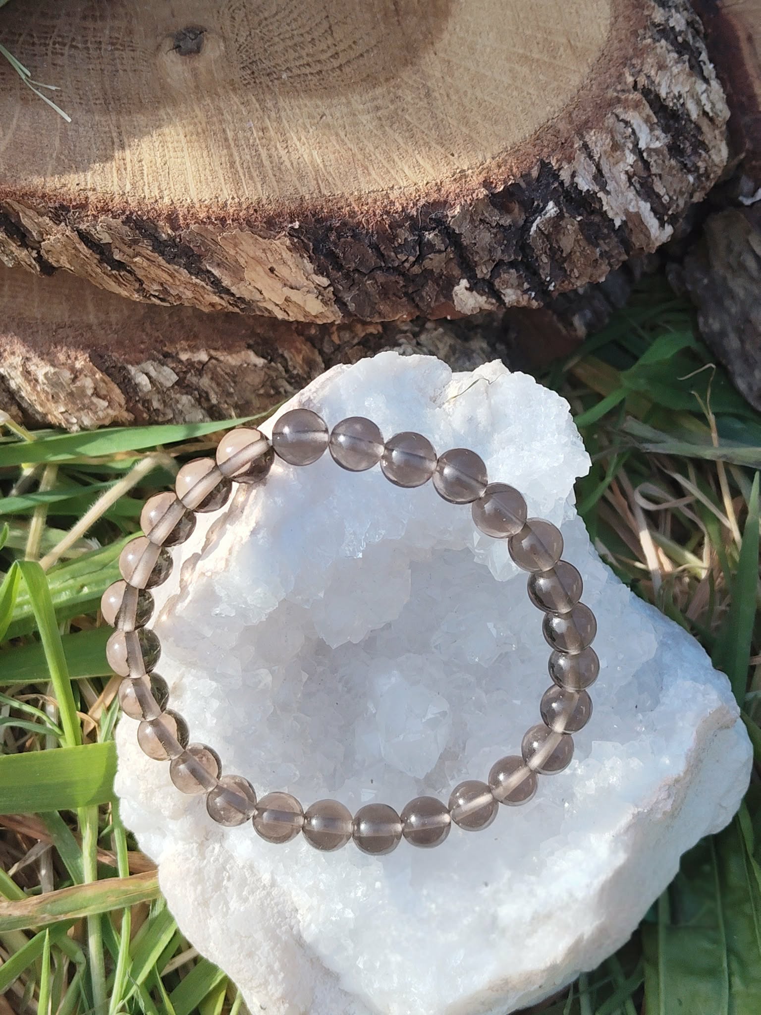 Bracelet obsidienne larme d’Apache 6 mm sur amas de quartz avec fond bois et feuillage, recul intérieur, stabilité nerveuse et énergie plus paisible