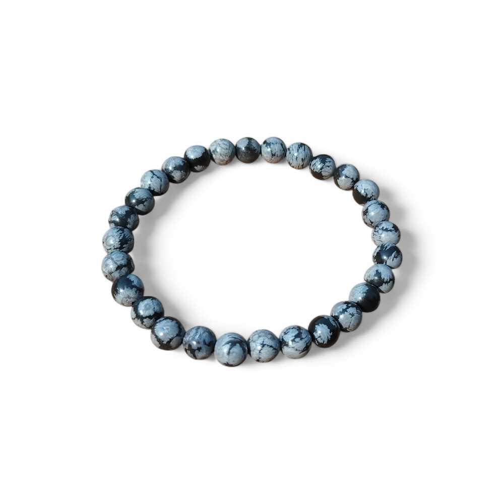 Bracelet obsidienne neige 6 mm sur fond blanc, perles noires mouchetées de gris, stabilité, recentrage et calme intérieur