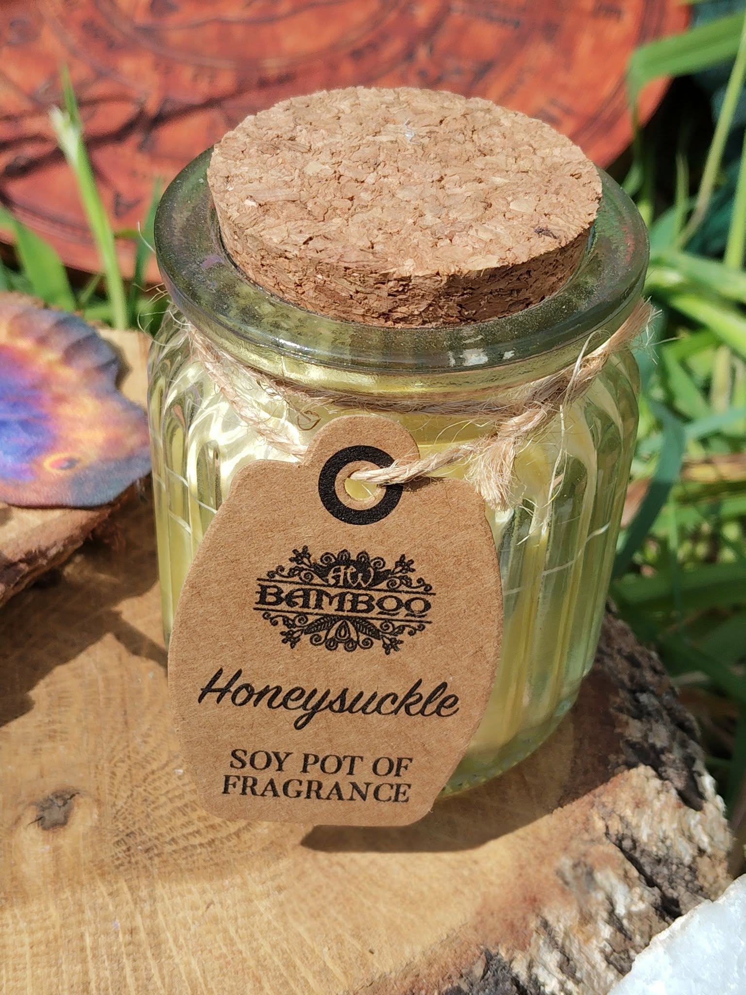 Bougie parfumée chèvrefeuille en cire de soja, pot verre couvercle liège, sur bois avec feuillage, douceur, détente, réconfort.
