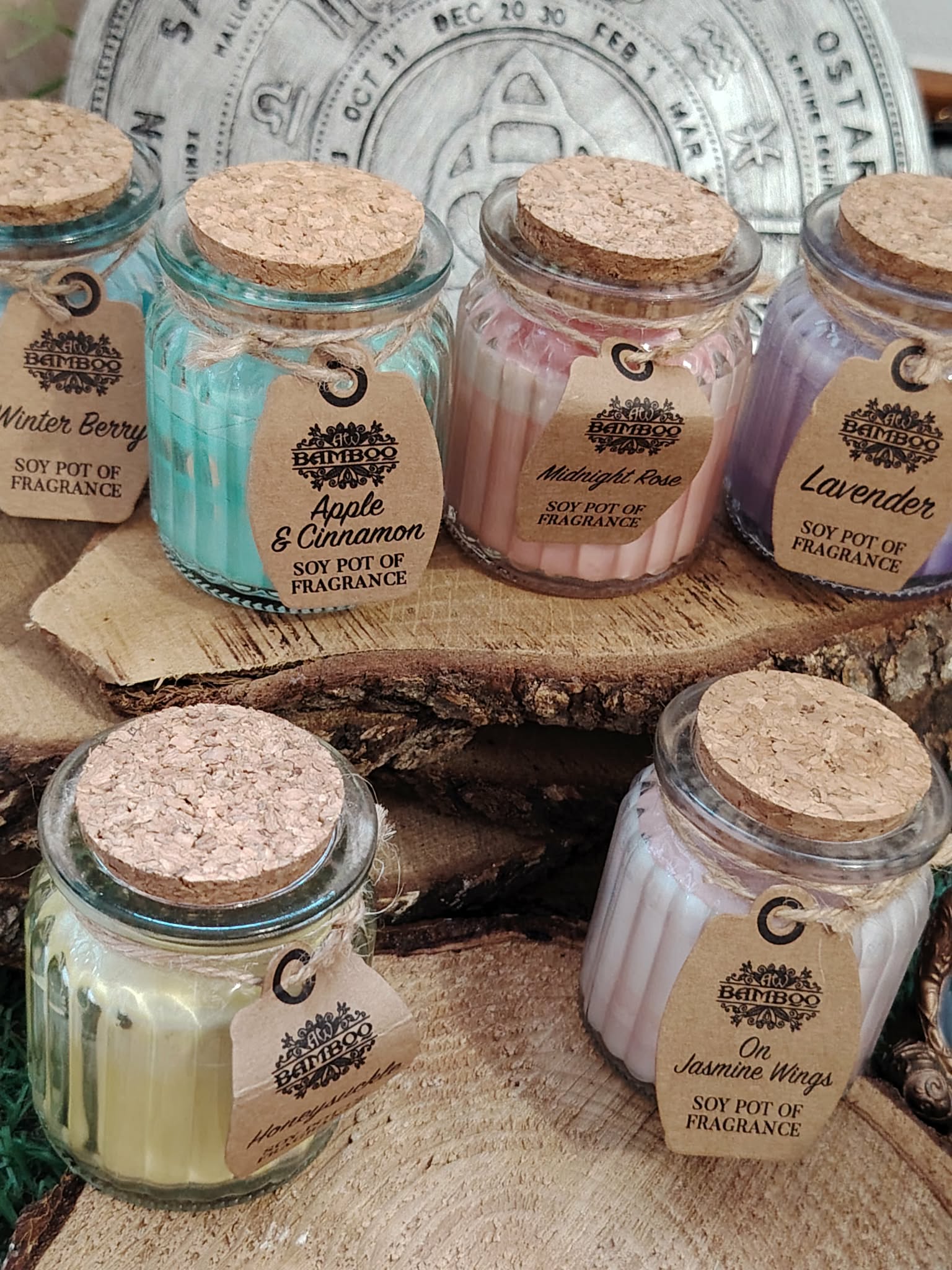 Bougies cire de soja en pots verre, couvercles liège, sur bois, couleurs variées, ambiance douce, apaisement, cocooning.