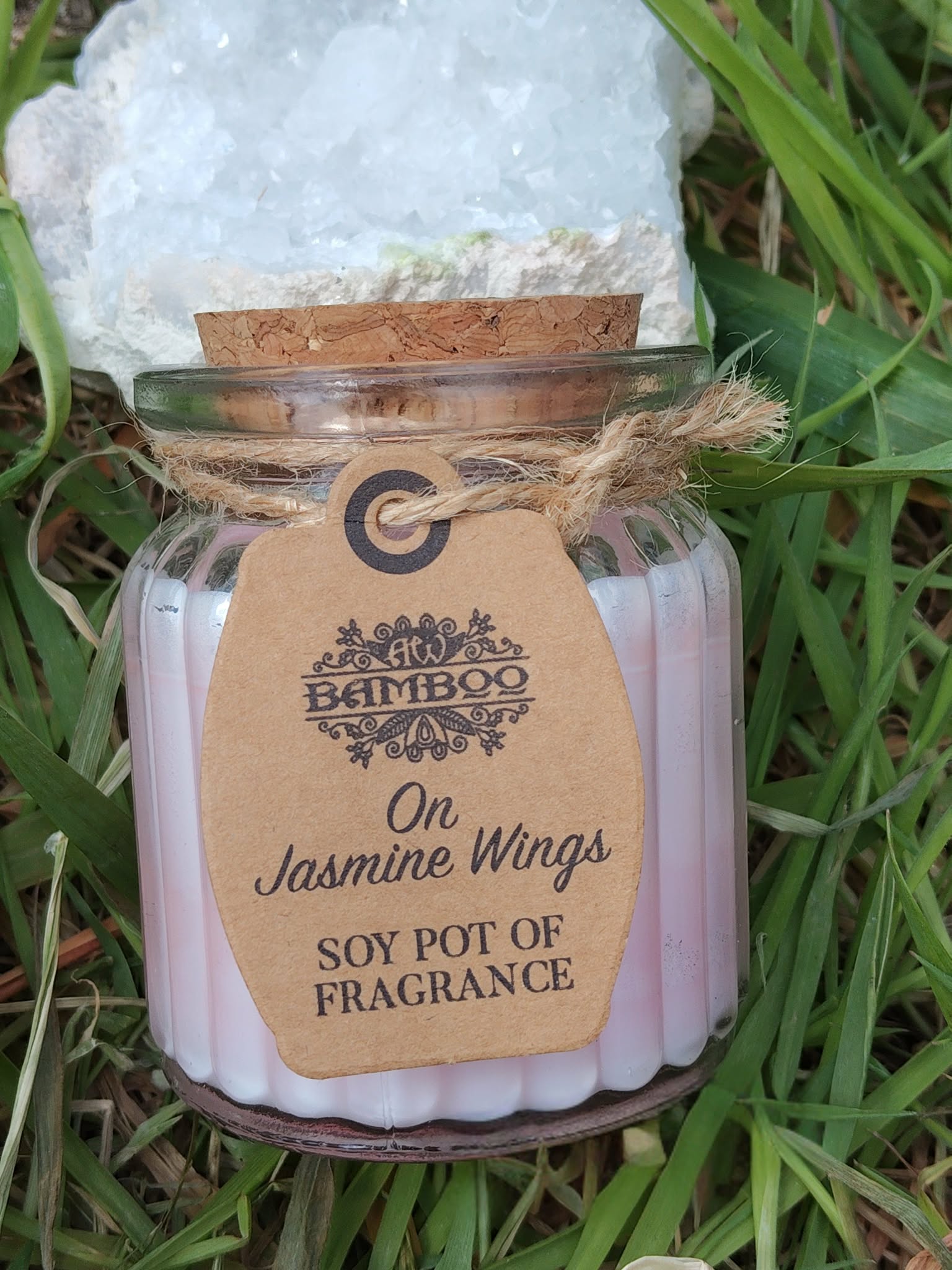 Bougie jasmin en cire de soja, pot verre avec couvercle liège, posée dans l’herbe, douceur, calme, réconfort, sérénité.
