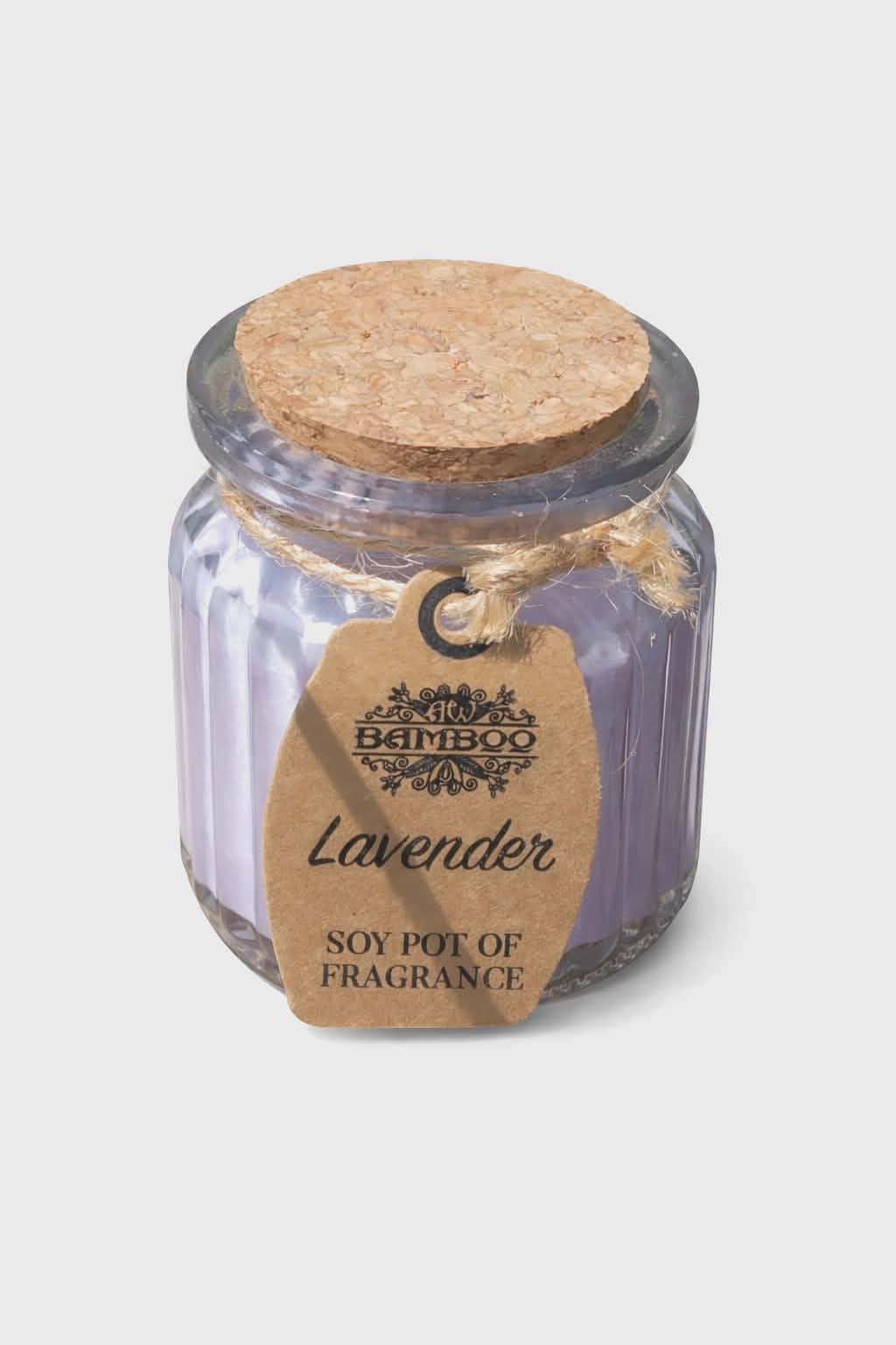Bougie lavande en pot de verre strié violet avec couvercle en liège, ficelle en jute et étiquette kraft, photo détournée sur fond blanc, ambiance apaisante, détente, douceur, sérénité.