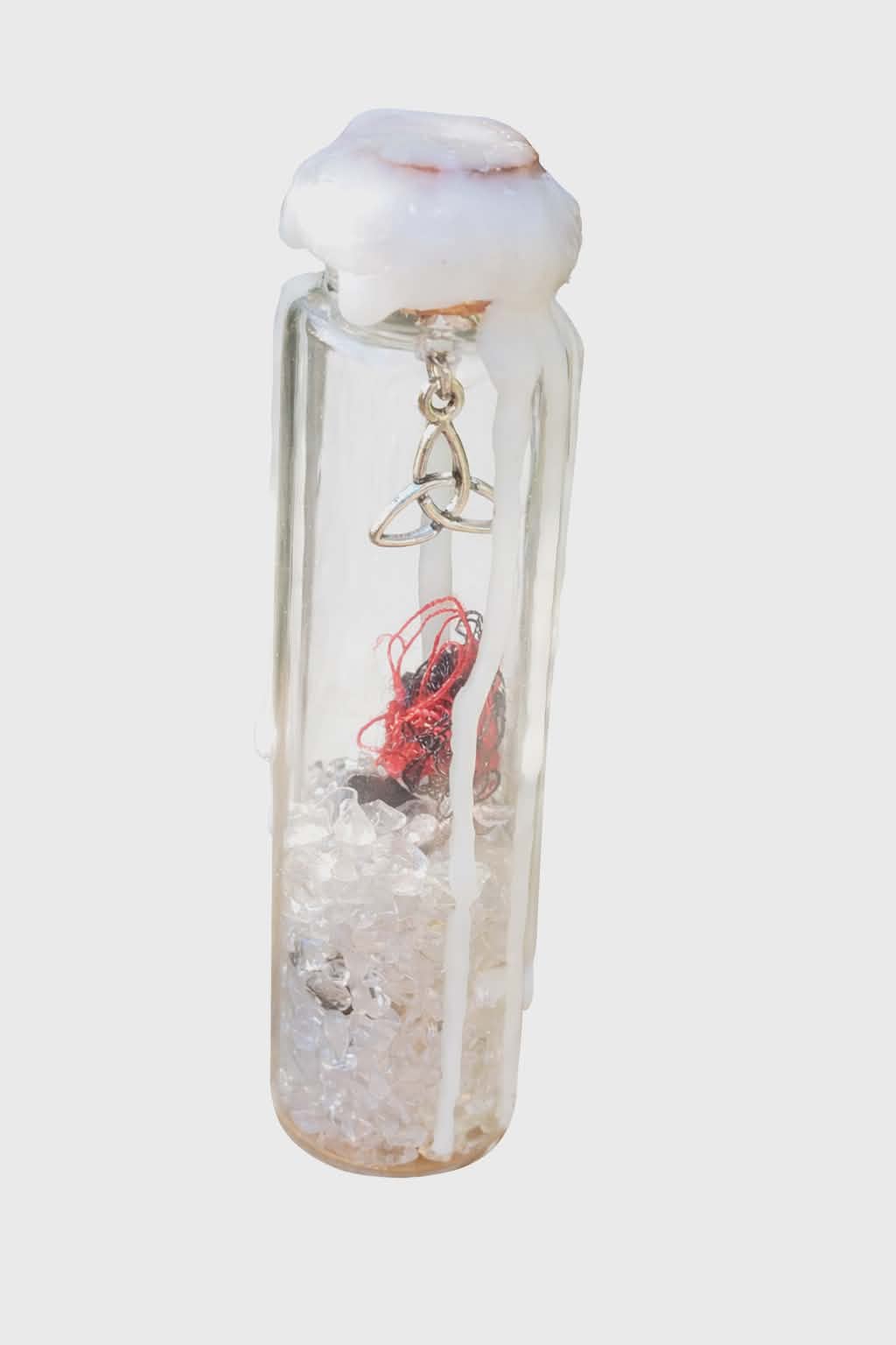 Spell jar (fiole de sort) en verre avec cristal de roche et fil rouge, scellée à la cire blanche, breloque triquetra argentée, photo détourée sur fond blanc.