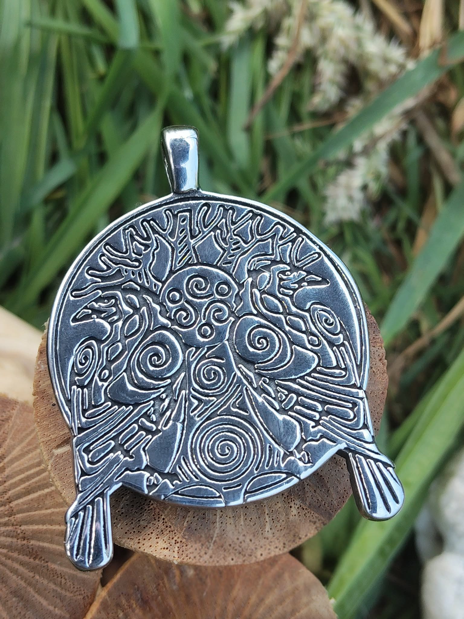 Pendentif viking noirci avec arbre sacré et deux corbeaux en relief, encadré par deux champignons en bois dans un décor végétal