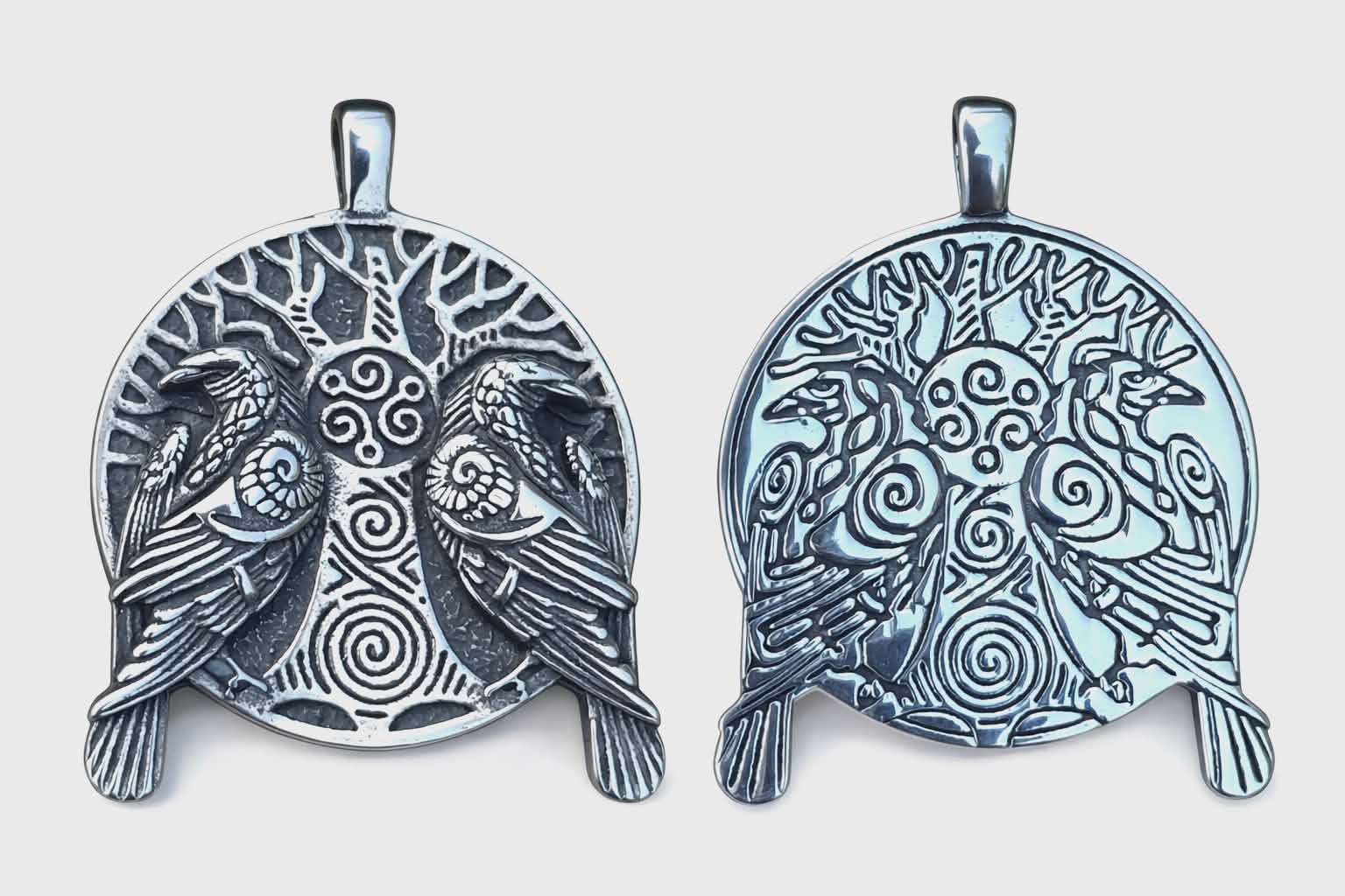 Pendentif viking réversible en métal argenté sur fond blanc, arbre sacré, doubles corbeaux et spirales triskèle au style mythologie nordique