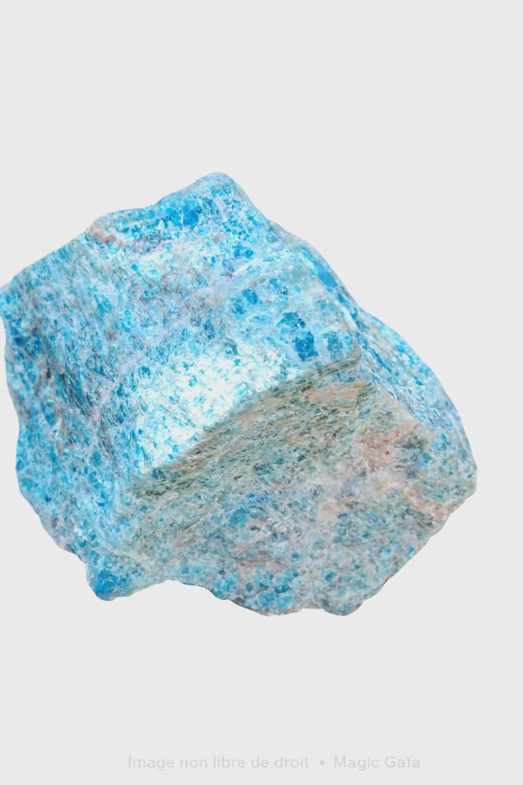 Apatite bleue brute non polie sur fond blanc, pierre naturelle reliée à la clarté d’esprit, à la confiance tranquille et à la parole fluide.