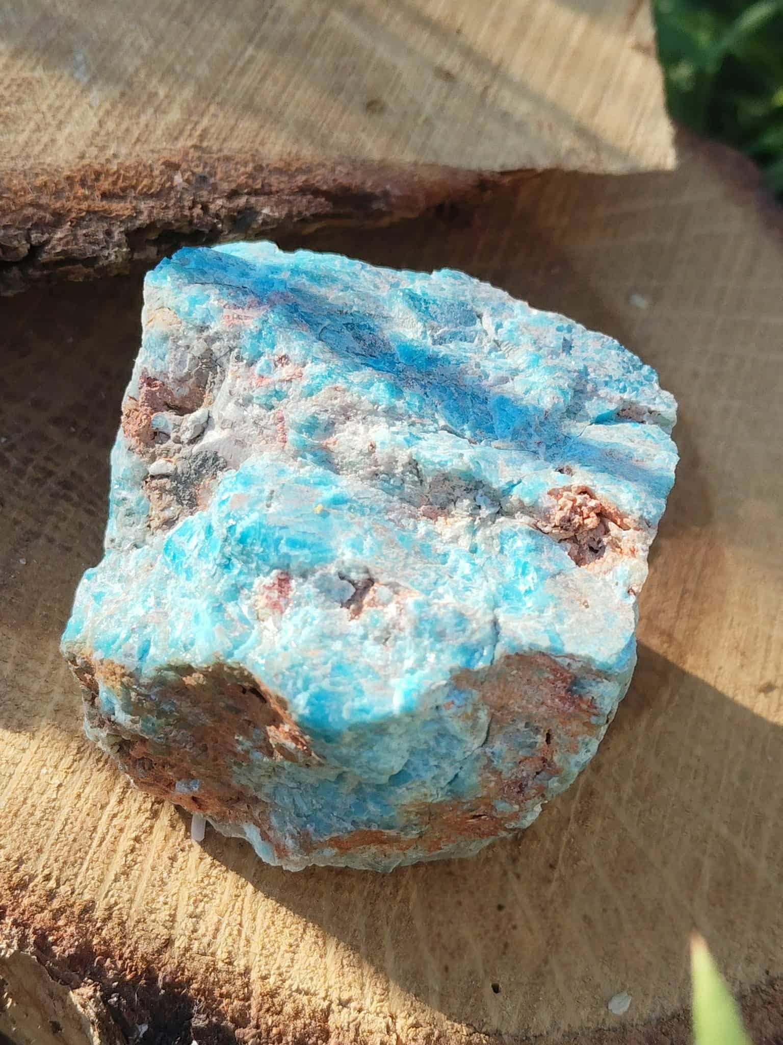 Apatite bleue brute bleu turquoise marbrée avec zones ocre sur fond blanc, pierre naturelle associée au recul, à la concentration et à l’inspiration personnelle.