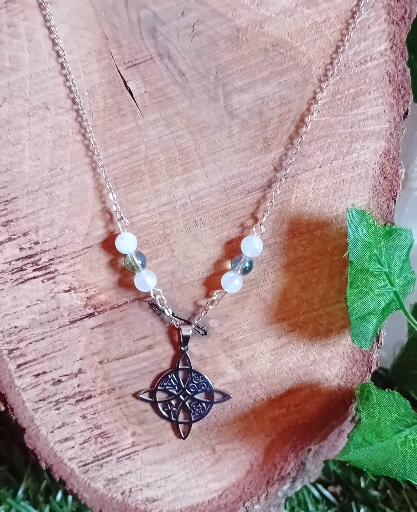 Pendentif nœud de sorcière sur chaîne acier inoxydable, perles blanches et iridescentes, décor bois et éléments verts, soutien douceur émotionnelle et intuition